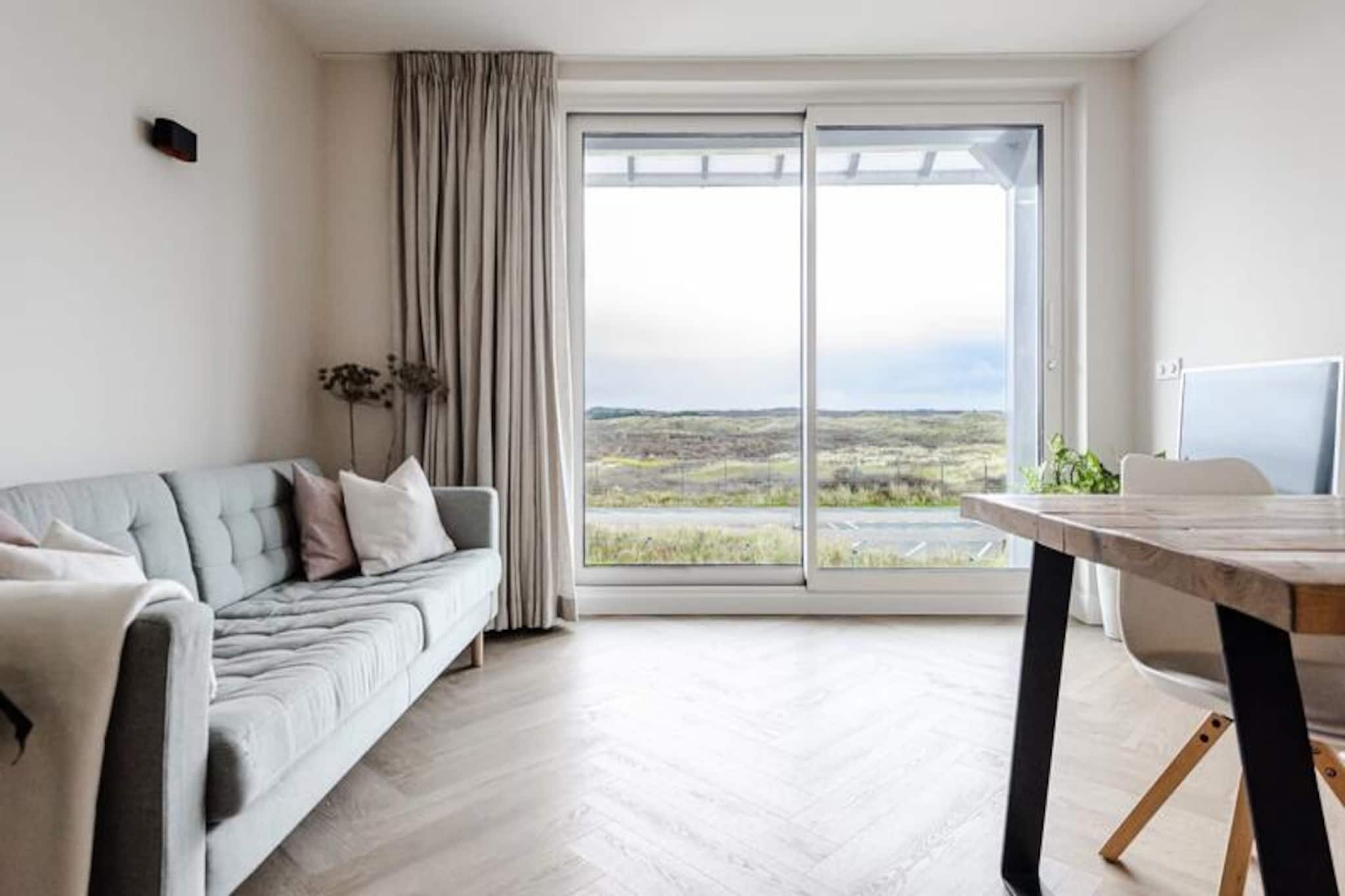 Where the golden dunes meet the serene coastline, this bright and modern apartment offers a tranquil retreat in the heart of Zandvoort. Bathed in natural light from large sea-facing windows, the space invites you to unwind and soak in the beauty of the surrounding landscape. Whether you're planning a family getaway or a peaceful escape, this apartment is your gateway to the best of beachside living. 
 
 Inside, the apartment is thoughtfully designed to accommodate up to four guests. The living room, with its comfortable sofa and dining area, is the perfect spot to relax after a day of exploring. The open-plan kitchen is fully equipped, making it easy to prepare meals with fresh local ingredients. Two cozy bedrooms ensure a restful night’s sleep: one with a double bed and another with a charming bunk bed illuminated by a skylight. Modern amenities like Wi-Fi, television, and provided linens and towels ensure a hassle-free stay. 
 
 Step outside, and you'll find yourself just moments from Zandvoort’s sandy beaches and the expansive dunes. The town center, with its vibrant cafes, shops, and restaurants, is within walking distance. For nature enthusiasts, the nearby De Waterleidingduinen and Kennemerduinen national parks offer endless opportunities for hiking and cycling. Thrill-seekers can head to the Circuit Park Zandvoort, just 1.2 km away, to experience the excitement of motorsports or even try their hand at racing. 
 
 Zandvoort is not just a summer destination—it’s a year-round haven. From beachside relaxation to winter walks through peaceful nature reserves, every season offers something unique. With easy access to Amsterdam via a quick train ride, this charming seaside village truly lives up to its nickname, \