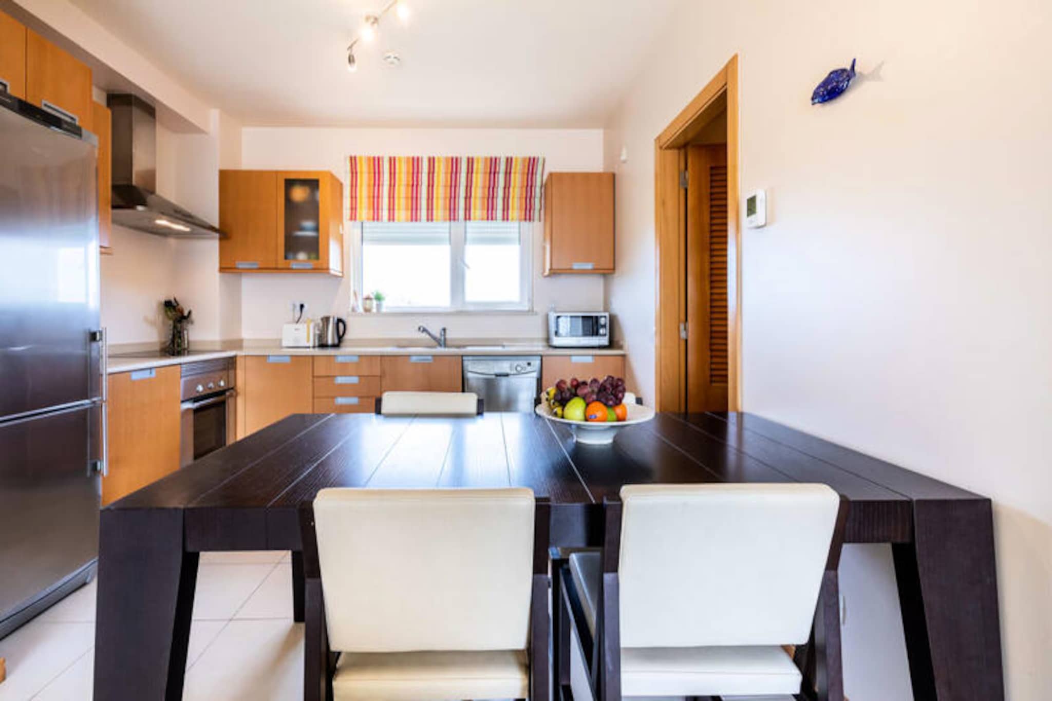 In the heart of the Algarve’s serene coastline, this sun-drenched apartment offers the perfect retreat for families and friends seeking relaxation and adventure. Nestled in the charming village of Burgau, this two-bedroom property with a mezzanine combines modern comfort with the timeless allure of Portugal’s southern coast. From the moment you step inside, the bright, airy interiors and large windows invite the golden sunlight to fill every corner, creating a warm and welcoming atmosphere. Multiple balconies provide the perfect spots to soak up the sun at any time of day, while the shared garden and swimming pool offer a refreshing escape. 

Designed to accommodate up to six guests, the apartment features two cozy bedrooms—one with a king-size bed and another with twin beds—alongside a mezzanine with a spacious double bed. The fully equipped kitchen is ideal for preparing meals to enjoy al fresco on the balcony overlooking the pool. With three bathrooms, air conditioning, Wi-Fi, and all linens provided, every detail has been considered to ensure your stay is as comfortable as possible. Please note that the mezzanine is not equipped with a child safety gate, and access to the apartment is via a staircase.

Just a 2-minute walk from the center of Burgau and less than 10 minutes from the beach, this location is a dream for sun-seekers and explorers alike. Stroll through the quaint streets of this fishing village, relax on the golden sands of Praia do Burgau, or venture further to discover the Algarve’s stunning coastline, hidden coves, and vibrant towns like Lagos, just 8 km away. Golf enthusiasts will appreciate the nearby courses, while surfers and adventurers can enjoy the region’s world-class waves and hiking trails.

Whether you’re here to unwind by the pool, explore the historic charm of the Algarve, or indulge in fresh seafood at local restaurants, this apartment offers the perfect base for an unforgettable holiday. Book now and let the Algarve’s beauty and tranquility rejuvenate your spirit.