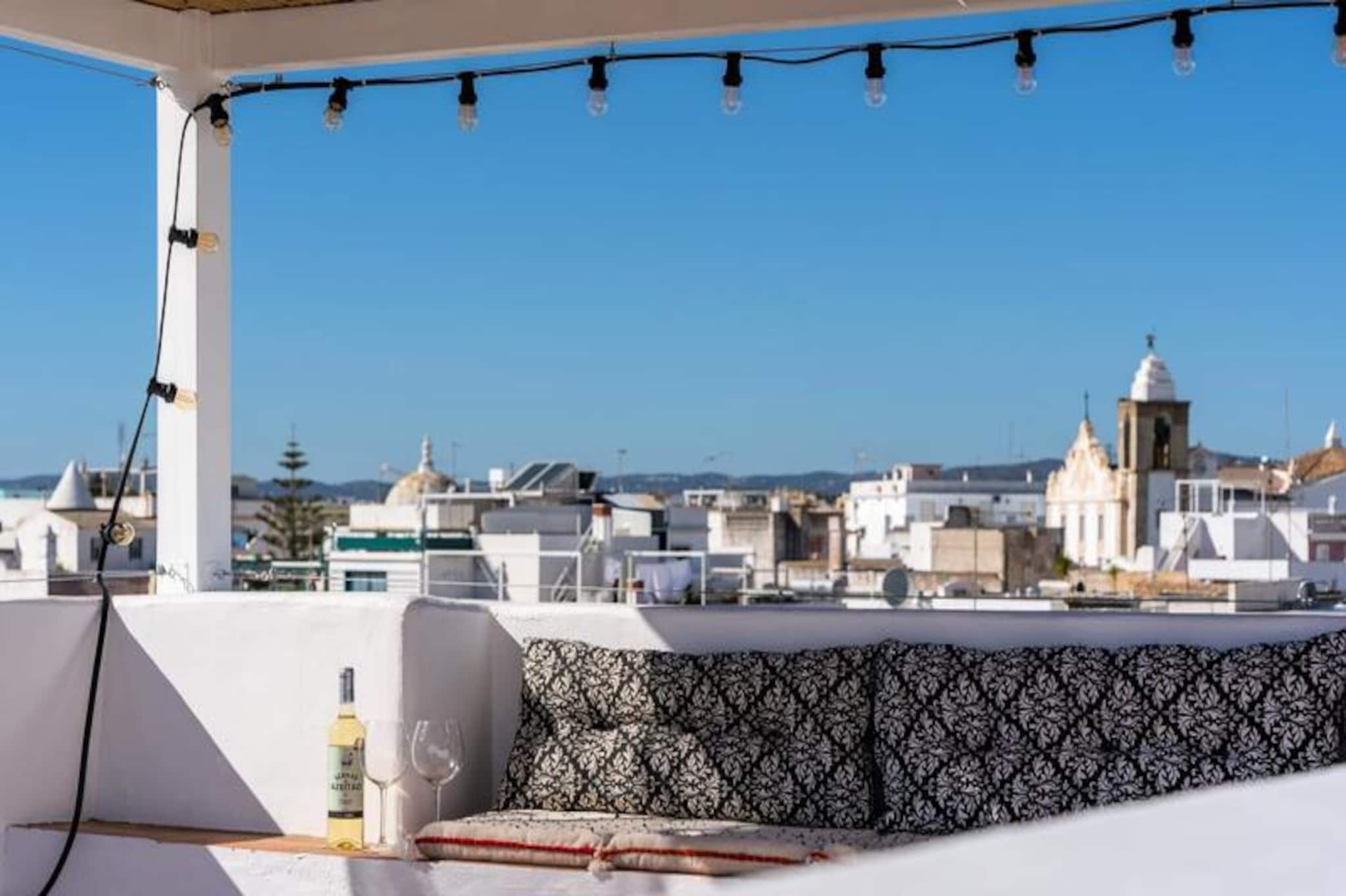 Step into the heart of Olhão, a vibrant coastal town in Portugal's Eastern Algarve, and immerse yourself in the charm of this unique historic apartment. Once the residence of the celebrated physician Francisco Fernandes Lopes, this property is a true gem, blending timeless elegance with modern comfort. From its traditional faux-marble ceilings to its panoramic rooftop terrace, every corner tells a story of heritage and beauty. 
 
 The apartment spans multiple levels, offering a warm and inviting atmosphere. On the first floor, you’ll find two spacious bedrooms, one with French doors that open onto a charming balcony and a small adjoining study. The second bedroom connects seamlessly through original wooden doors, preserving the home’s historic character. Ascend the narrow stone staircase to the second level, where an open-plan living room and kitchen lead to a large outdoor terrace, perfect for al fresco dining. The crowning jewel is the sun-drenched rooftop terrace on the fourth floor, offering breathtaking views of the islands of Armona, Culatra, and Fuzeta. 
 
 Located just steps from Olhão’s main promenade, this apartment places you at the gateway to the Algarve’s tranquil islands. Stroll through the cobbled streets of the Fishermen’s Quarter, explore the vibrant fresh market, or enjoy the local cuisine at nearby restaurants. The ferry to the islands is just minutes away, making it easy to discover the pristine beaches and natural beauty of the region. 
 
 Whether you’re seeking a peaceful retreat or an adventure-filled getaway, this historic apartment offers the perfect base to experience the best of Olhão and the Algarve. Book your stay today and create unforgettable memories in this enchanting coastal town.