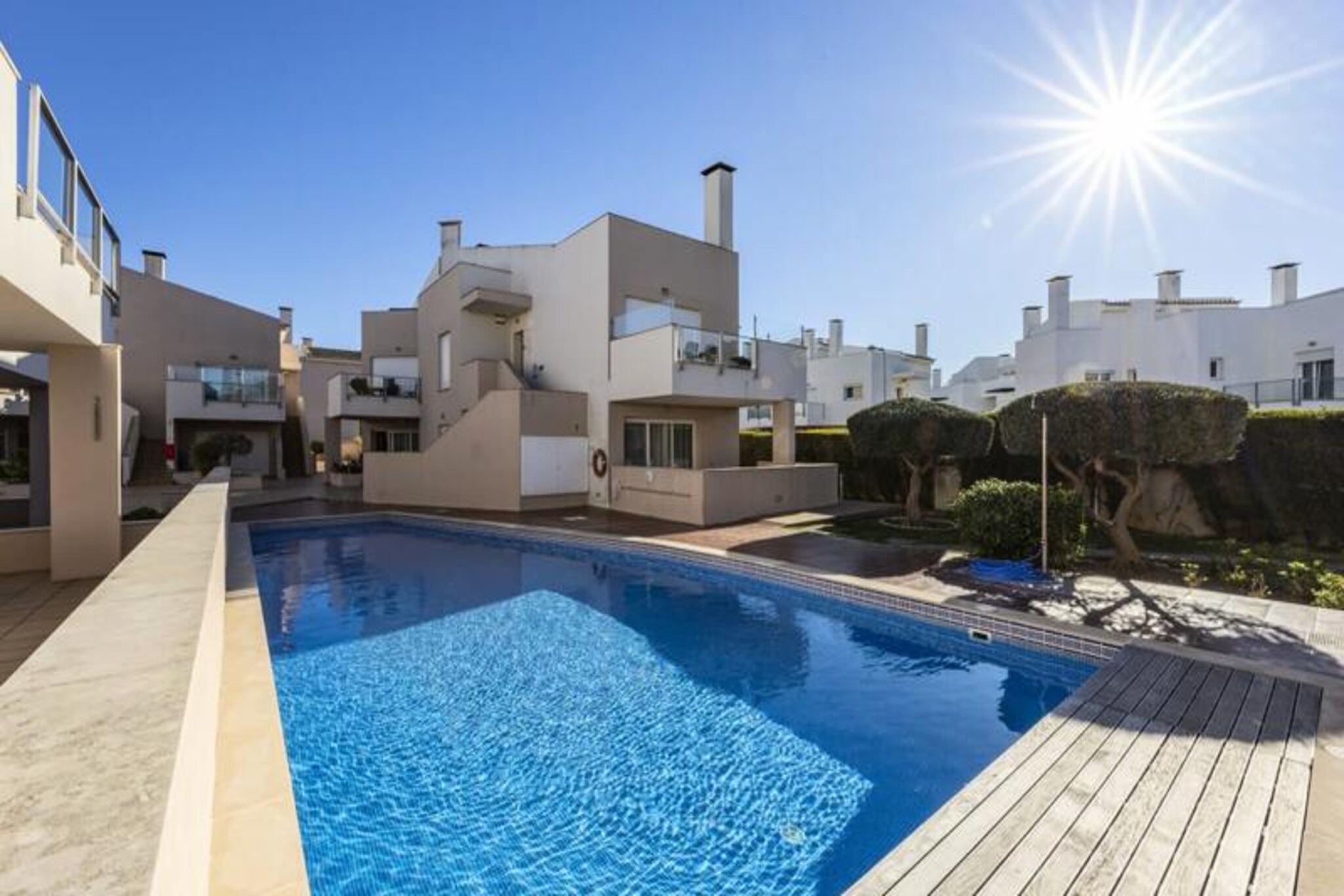 In the heart of the Algarve’s sun-kissed coastline, this elegant two-bedroom apartment offers a serene escape for families or couples seeking a blend of comfort and coastal charm. Imagine waking up to the gentle sound of waves and enjoying your morning coffee on one of the sunny balconies, with views of the lush shared garden and sparkling swimming pool. This tranquil retreat is perfect for up to four guests, providing a peaceful haven just steps away from the vibrant village of Burgau. 
 
 The apartment boasts a modern and spacious interior, thoughtfully designed to ensure a relaxing stay. The open-plan living area is flooded with natural light from large windows, creating a warm and inviting atmosphere. A fully equipped kitchen allows you to prepare delicious meals, while the outdoor dining area overlooking the pool is perfect for al fresco evenings under the stars. The two bedrooms, one with a double bed and the other with twin beds, offer restful nights, complemented by an en-suite bathroom and a separate bathroom for added convenience.
 
 Just a two-minute walk from Burgau’s charming town center and less than ten minutes from the beach, this property places you in the heart of one of the Algarve’s most picturesque villages. Explore the cobblestone streets, dine at seaside restaurants, or relax on the sheltered beaches framed by dramatic cliffs. For the more adventurous, a short drive will take you to world-class surfing beaches, three renowned golf courses, and the historic town of Lagos with its marina and vibrant dining scene.
 
 Whether you’re seeking relaxation or adventure, this apartment offers the perfect base to discover the Algarve’s beauty. With air conditioning, Wi-Fi, and secure parking included, your stay promises to be as comfortable as it is unforgettable. Let the charm of Burgau and the allure of the Algarve create memories you’ll cherish forever.