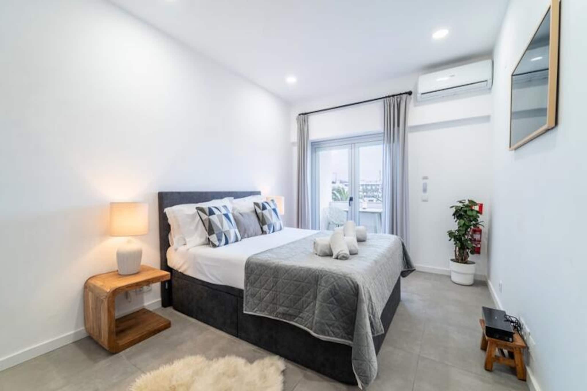 Awaken your senses in the heart of Lagos, where this beautifully renovated studio offers a serene escape with breathtaking marina views. Imagine sipping a glass of wine on the balcony as the sun sets over the water, painting the sky with hues of gold and crimson. This modern retreat is perfect for couples seeking a romantic getaway or solo travelers looking to immerse themselves in the vibrant charm of Portugal's Algarve coast. With its unbeatable location, the studio serves as a gateway to the historic center, stunning beaches, and lively harbor—all just a short stroll away. \n\nStep inside and discover a thoughtfully designed space that blends comfort and style. The queen-size bed invites restful nights, while the private bathroom with a luxurious rain shower ensures relaxation after a day of exploring. The well-equipped kitchen allows you to prepare meals with ease, and the high ceilings and open windows create an airy ambiance that feels both welcoming and sophisticated. Modern amenities like Wi-Fi and TV add convenience, making this studio a true home away from home. \n\nOutside your door, Lagos unfolds with endless possibilities. Wander through cobblestone streets lined with traditional houses, browse local shops, or savor fresh seafood at waterfront restaurants. Adventure awaits on the cliffs and waters of the Algarve—whether kayaking through hidden caves, sailing along the coast, or simply soaking up the sun on golden sands. The marina area offers live music, bustling bars, and a large supermarket for all your needs. \n\nWhether you’re here for relaxation or exploration, this studio is your perfect base to experience the magic of Lagos. Let the charm of this coastal town and the comfort of your accommodation create unforgettable memories.