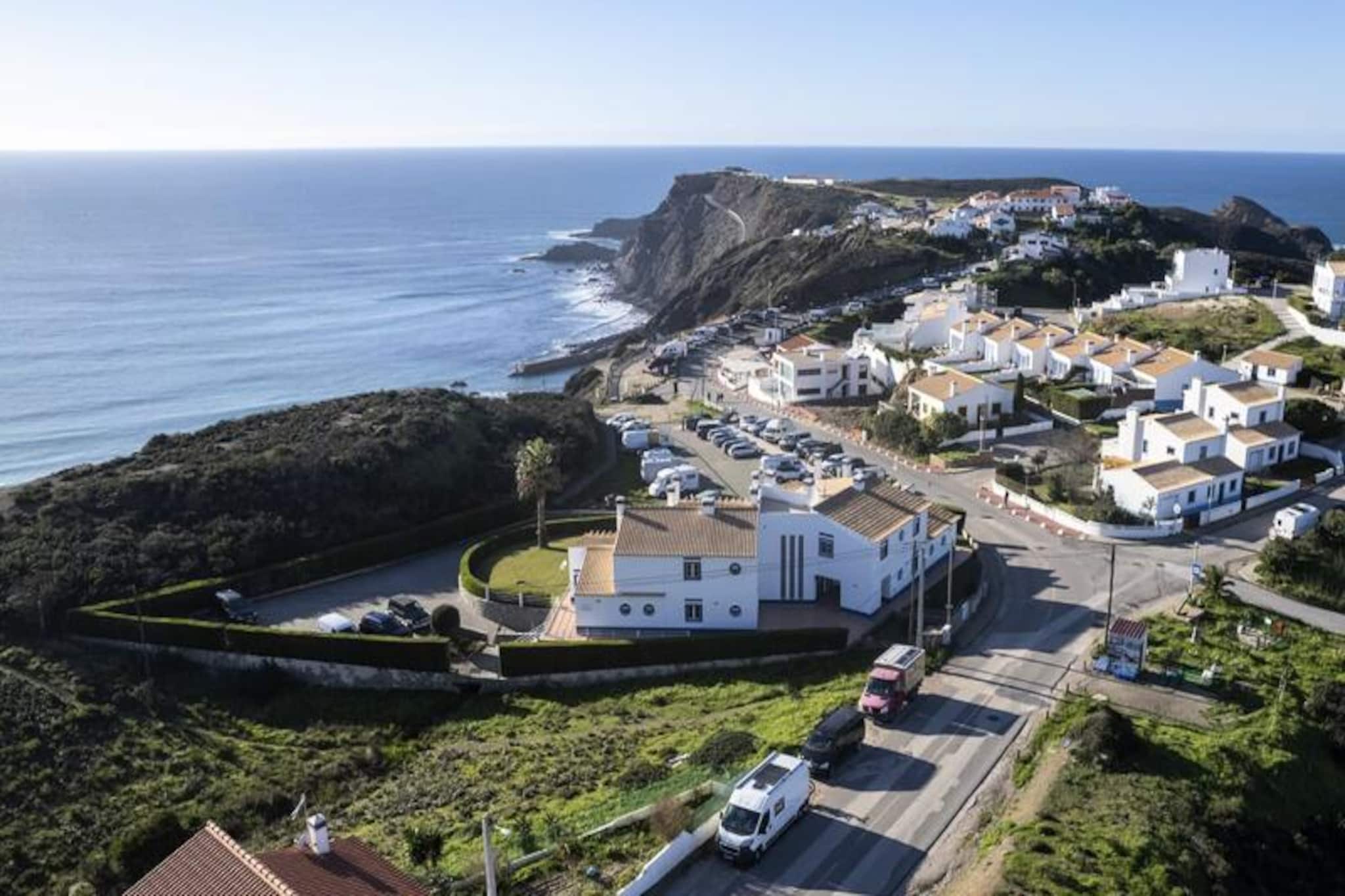 High above the dramatic cliffs of Praia da Arrifana, this cozy one-bedroom apartment invites you to immerse yourself in the laid-back surf culture of Portugal’s Algarve. With its stunning ocean views and tranquil surroundings, it’s the perfect retreat for couples seeking a blend of adventure and relaxation. Imagine waking up to the sound of waves crashing below, enjoying your morning coffee as the sun rises over the horizon, and heading out for a day of surfing or exploring the rugged coastline. This is more than just a holiday—it’s a chance to reconnect with nature and yourself.
Inside, the apartment offers a minimalist yet inviting design, with natural textures and calming tones that reflect the beauty of the surrounding landscape. The living room is a welcoming space to unwind after a day in the sun, while the fully equipped kitchen makes it easy to prepare meals or snacks. The recently renovated Balinese-style bathroom features a spacious walk-in shower, perfect for washing off the salt and sand. While the apartment does not have air conditioning, its thoughtful design ensures a comfortable atmosphere throughout your stay.
Step outside and you’re just moments away from catching the perfect wave or enjoying a leisurely stroll along the cliffs. In the evening, fire up the barbecue and savor a meal as the sun sets over the Atlantic. For those who prefer a slower pace, the nearby village offers charming cafés and breathtaking sea views. With super-fast Wi-Fi, you can stay connected while still feeling worlds away from the everyday.
Whether you’re here to ride the waves, explore the coastal trails, or simply soak up the serene atmosphere, this apartment provides the ideal base for your Algarve adventure. From its stunning location to its thoughtful amenities, every detail has been designed to make your stay unforgettable. Discover the magic of Arrifana and create memories that will last a lifetime.