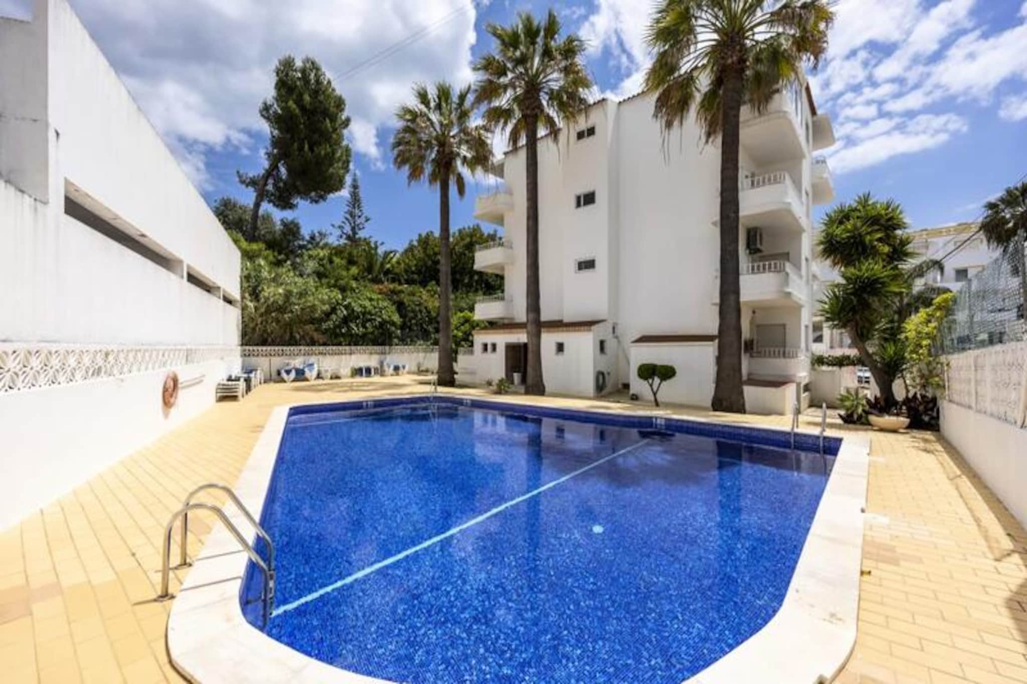 Step into a world of sunlit charm and coastal elegance in this delightful 2-bedroom apartment in Carvoeiro, a gem on Portugal’s Algarve coast. Just a short 5-minute stroll from golden beaches and the azure Atlantic, this inviting retreat offers the perfect blend of relaxation and adventure for families, couples, or friends seeking an unforgettable escape. Wake up to the gentle sound of waves and let the vibrant energy of this seaside village set the tone for your holiday. 
 
 Inside, the apartment is designed with comfort and style in mind. The master bedroom features a plush king-size bed, while the second bedroom offers two cozy single beds, making it ideal for both families and groups. Two modern bathrooms ensure convenience, while the bright, open-plan living area boasts a sofa bed, a fully equipped kitchen, and air conditioning for year-round comfort. Start your day with coffee on the enclosed winter balcony and unwind in the evening on the private outdoor balcony, soaking in the serene ocean breeze. Guests also have access to a shared swimming pool, perfect for cooling off after a day of exploring. 
 
 Carvoeiro’s charm lies in its stunning natural beauty and vibrant local culture. From dramatic cliffs and scenic coastal walks to charming restaurants serving the freshest seafood, everything is within easy reach. For the adventurous, water sports, golf, and hiking in the nearby Serra de Monchique mountains await. Whether you’re exploring hidden beaches accessible only by boat or savoring local delicacies at a seaside café, Carvoeiro offers something for every traveler. 
 
 With its central location, modern amenities, and warm ambiance, this apartment is your gateway to experiencing the best of the Algarve. Book your stay and create memories that will last a lifetime.