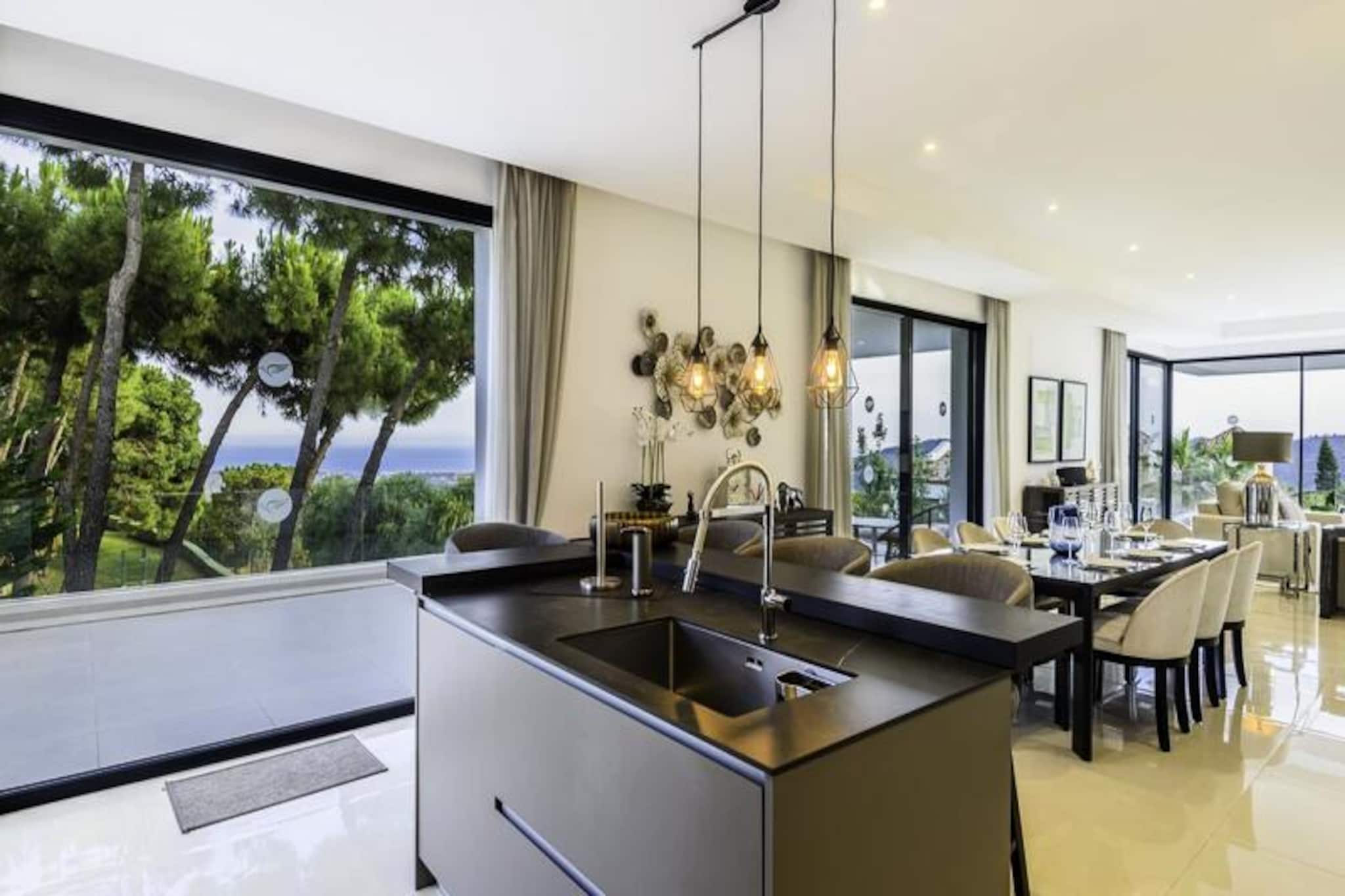 In the serene hills of Monte Mayor, Villa Condor offers a luxurious retreat where modern sophistication meets the tranquility of nature. Surrounded by lush landscapes and breathtaking views of the Mediterranean, Gibraltar, and even the North African coast on clear days, this villa is a haven for those seeking both relaxation and adventure. The exclusive community of Monte Mayor ensures privacy, security, and a sense of exclusivity, making it the perfect destination for a memorable getaway.
This stunning five-bedroom villa, completed in 2019, is designed with elegance and functionality in mind. The ground floor features an open-plan living and dining area with large south-facing windows that flood the space with natural light. The fully equipped kitchen is a chef’s dream, while the terraces offer panoramic views and are perfect for al fresco dining. The villa boasts a private elevator, a state-of-the-art home automation system, and luxurious amenities such as a heated pool, jacuzzi, and sauna. The master bedroom, with its private terrace and en-suite bathroom, is a sanctuary of comfort, while the rooftop terrace provides unparalleled vistas. The basement adds a touch of fun with a social lounge, bar, pool table, and foosball table, ensuring entertainment for all ages.
Villa Condor’s location is ideal for exploring the Costa del Sol. Prestigious golf courses, pristine beaches, and charming towns like Benahavís and Marbella are just a short drive away. Whether you’re hiking scenic trails, indulging in world-class dining, or enjoying water sports along the coast, the region offers endless opportunities for adventure.
Choose Villa Condor for a holiday that combines luxury, comfort, and the natural beauty of southern Spain. With Marbella Banus’s exceptional service, your stay will be nothing short of extraordinary.