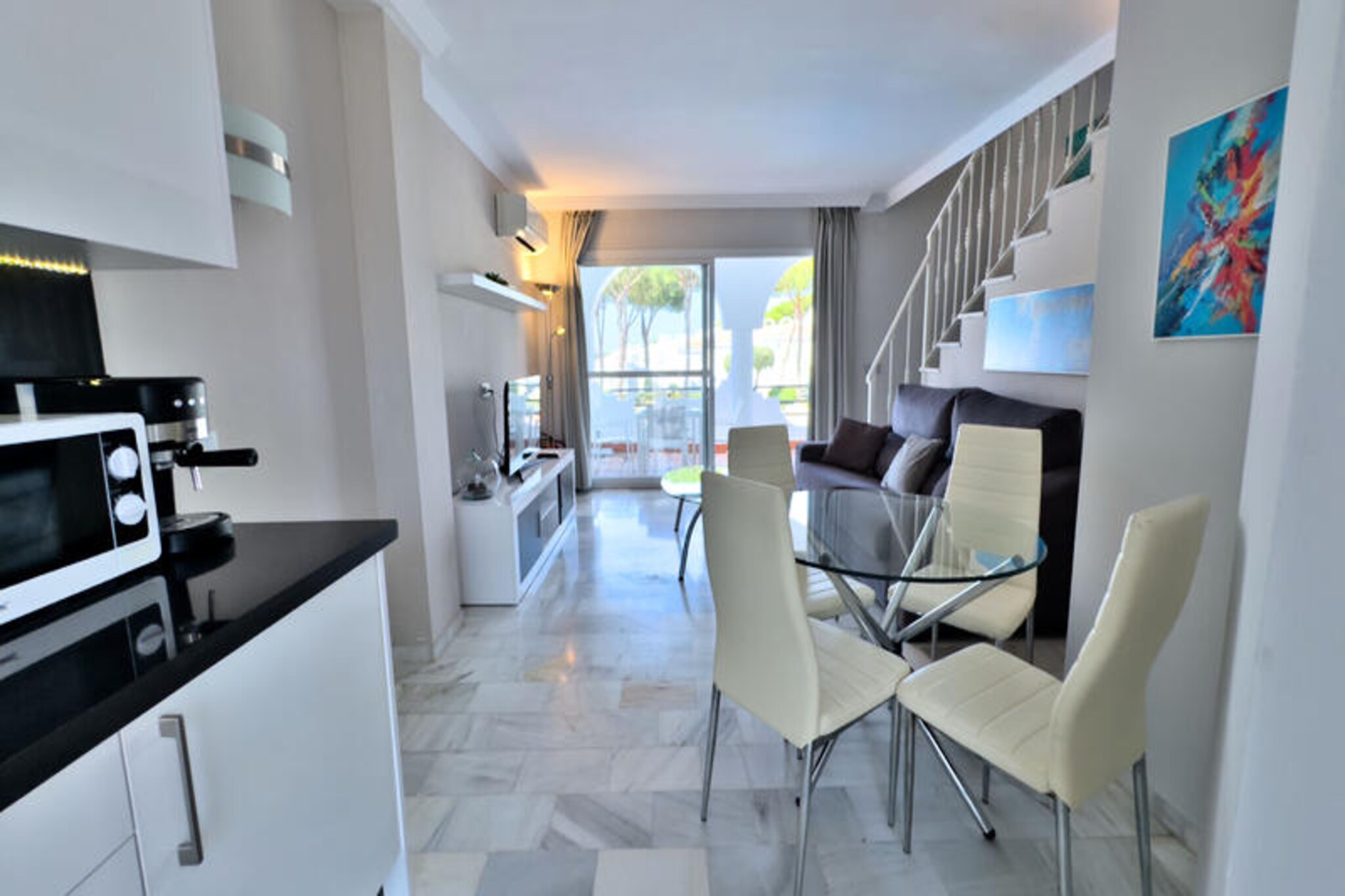 Step into a world of Mediterranean charm and modern comfort at this stunning two-bedroom duplex townhouse, nestled within the exclusive Vime Marbella Hotel complex. With its sunlit terraces, lush gardens, and access to top-tier amenities, this property is your gateway to an unforgettable holiday in the heart of Marbella. Whether you're sipping your morning coffee on the private patio or unwinding on the southwest-facing terrace with breathtaking views of the pools and gardens, every moment here is designed to immerse you in relaxation and luxury. 
 
 Spanning 69 m² across two thoughtfully designed floors, the townhouse offers a seamless blend of style and functionality. The ground floor welcomes you with a bright living-dining area, an open-plan kitchen fully equipped for culinary adventures, and a cozy double bedroom with an en-suite shower room. Step outside to your private terrace, where the sparkling communal pools beckon just beyond. Upstairs, you'll find a second bedroom with a built-in wardrobe and access to a spacious terrace, perfect for soaking up the Andalusian sun. A second full bathroom with a shower ensures convenience for all guests.
 
 As part of the Vime Marbella Hotel complex, you'll enjoy access to an array of exceptional facilities. Dive into one of the two outdoor pools or relax in the heated indoor pool and sauna. Indulge in Mediterranean flavors at the Fontanella buffet restaurant or the bar-restaurant, and treat yourself to a day of luxury with Balinese beds and refreshing cocktails. Families will appreciate the children's playground and activities, while fitness enthusiasts can make use of the fully equipped gym. With free high-speed Wi-Fi, ample parking, and convenient transfer services, every detail has been considered to enhance your stay.
 
 Beyond the resort, Marbella's treasures await. Explore the golden sands of nearby beaches like Cabopino and Artola, or wander through the enchanting streets of Marbella's historic center. For nature lovers, the Artola Dunes Natural Monument offers scenic hiking trails, while the glamour of Puerto Banús promises world-class shopping, vibrant nightlife, and unforgettable entertainment. Whether you're seeking a romantic getaway, a family retreat, or a fun-filled escape with friends, this townhouse is the perfect base for your Marbella adventure. Book now and let the magic of MarbellaBanus captivate you.