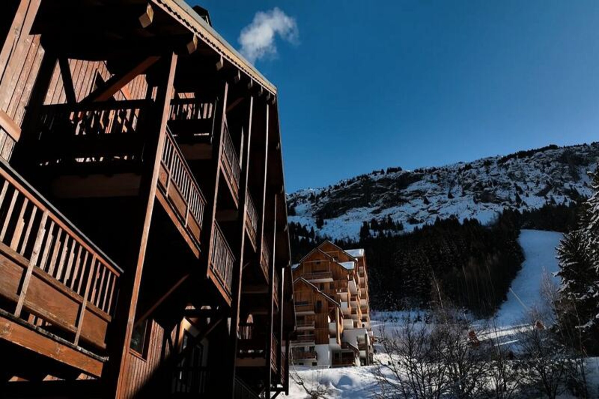 High in the heart of the French Alps, where snow-dusted peaks meet serene alpine charm, Résidence Oz en Oisans**** offers an unforgettable mountain retreat. Situated at the foot of the slopes in the picturesque village of Oz en Oisans, just 50km from Grenoble, this residence is a haven for winter sports enthusiasts and nature lovers alike. With 245km of pistes at your doorstep, the resort provides endless opportunities for skiing, snowboarding, and exploring the breathtaking landscapes of the Grandes Rousses massif. 
 
 The residence itself is composed of five traditional stone and wood chalets, exuding authentic alpine character. Families and groups will appreciate the warm, welcoming atmosphere and the thoughtful amenities designed to enhance your stay. Each accommodation features a cozy living room, a fully equipped kitchen, a comfortable bedroom with twin beds, and a private balcony where you can soak in the crisp mountain air. Modern conveniences such as Wi-Fi access at reception, included bed linen and towels, and the option to borrow raclette or fondue grills ensure a seamless and enjoyable experience.
 
 Guests can unwind in the relaxation center, which includes a heated indoor pool, a sauna, and a fitness room—perfect for rejuvenating after a day on the slopes. Practical touches like ski lockers, a ski rental shop, and covered parking add to the convenience, while pet-friendly policies mean you can bring your furry companions along. 
 
 Beyond the residence, the charming village of Oz en Oisans offers additional attractions, including an ice rink and a climbing wall, making it an ideal destination for all ages. Whether you’re here to carve through pristine snow, savor local alpine cuisine, or simply bask in the tranquility of the mountains, Résidence Oz en Oisans**** promises a holiday filled with unforgettable moments.