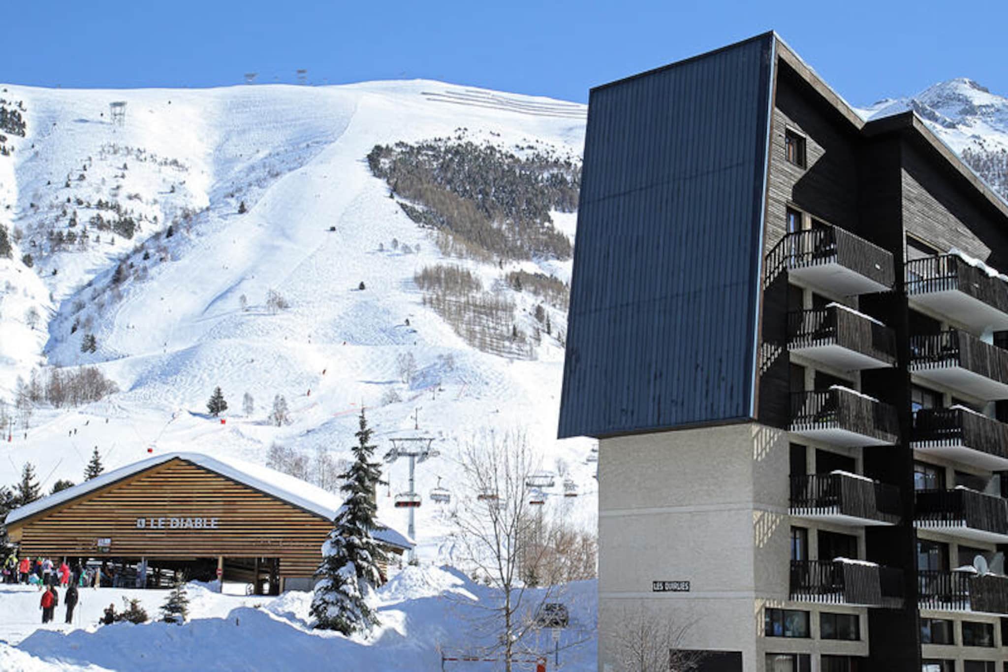High above the charming village of Les Deux Alpes, this cozy apartment offers a perfect blend of alpine comfort and modern convenience. With the Diable ski lift just 50 meters away, you’ll be on the slopes in no time, ready to carve through the pristine snow or enjoy the breathtaking mountain views. The west-facing balcony invites you to unwind after a day of adventure, soaking in the golden hues of the setting sun as it dips behind the peaks. Whether you’re here for winter sports or summer hikes, this retreat promises unforgettable moments in the heart of the French Alps. \n\nStep inside and discover a thoughtfully designed space that caters to your every need. The apartment features an open-plan living room and kitchen equipped with everything from a raclette grill to a Nespresso machine, ensuring you can savor local culinary delights in the comfort of your home away from home. The living area, complete with a sofa, armchairs, television, DVD player, and Bluetooth speaker, offers a cozy spot to relax and recharge. Two inviting bedrooms provide flexible sleeping arrangements, including bunk beds and a double bed, perfect for families or small groups. Additional amenities like a boot dryer, washer-dryer, and ski locker enhance your stay, making it as seamless as it is enjoyable. \n\nBeyond the apartment, Les Deux Alpes beckons with its vibrant atmosphere and endless activities. The ESF ski school meeting points are just 550 meters away, making it ideal for beginners and seasoned skiers alike. In summer, the region transforms into a haven for hikers and cyclists, with trails that wind through lush landscapes and offer panoramic views of the surrounding mountains. Local restaurants, shops, and après-ski venues ensure you’re never far from the lively spirit of the village. \n\nWhether you’re chasing powder in winter or exploring alpine trails in summer, this apartment is your gateway to the best of Les Deux Alpes. Experience the magic of the mountains and create memories that will last a lifetime.