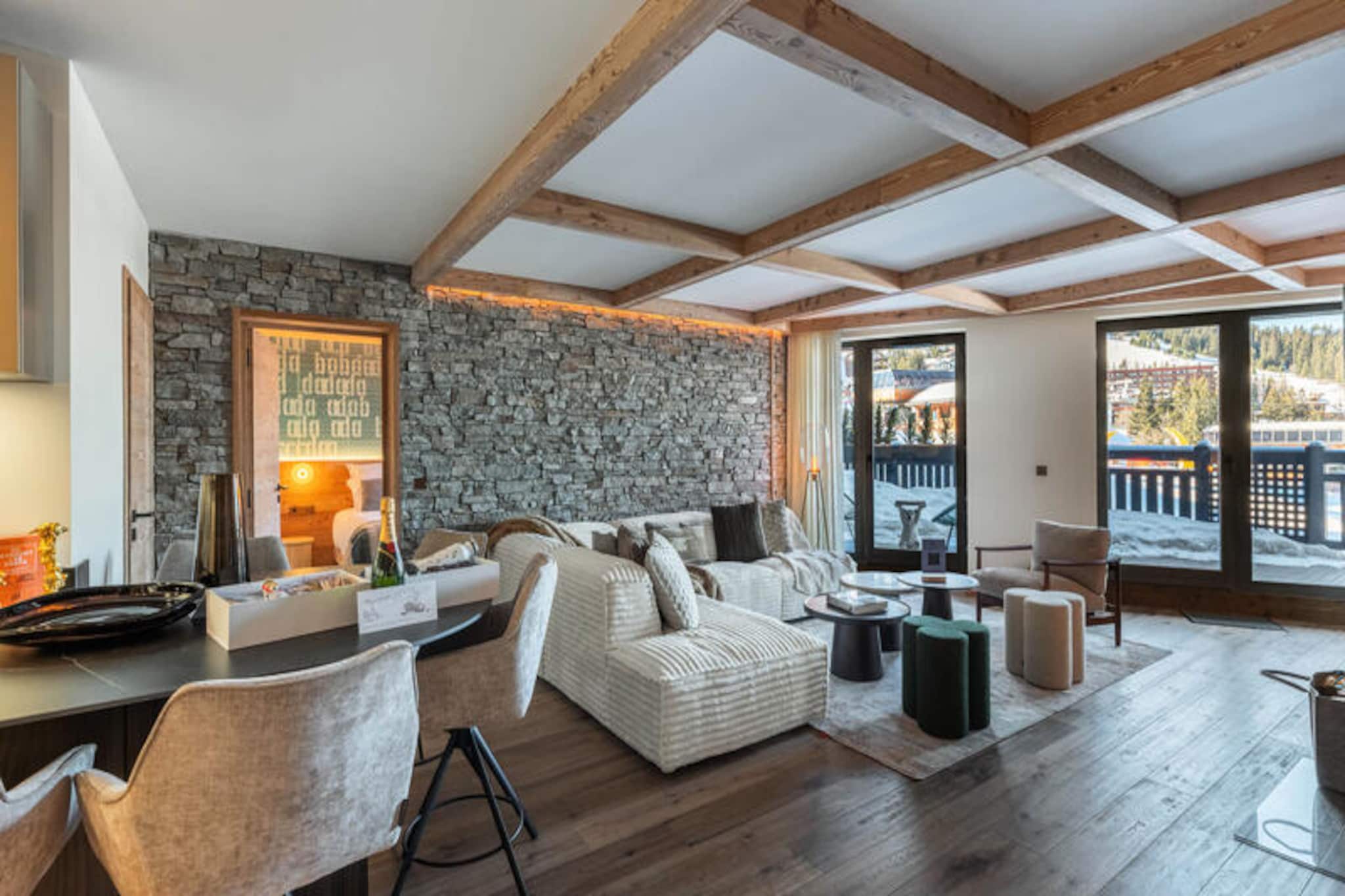 In the heart of Courchevel 1850, where luxury meets alpine charm, this exquisite new residence offers an unparalleled mountain retreat. Imagine waking up to the crisp mountain air, stepping onto your private balcony, and gazing out at the snow-dusted peaks that surround you. With the ski slopes just outside your door, this is the ultimate destination for those seeking a seamless ski-in, ski-out experience in one of the world’s most prestigious resorts.
Spanning 86 square meters, this elegant apartment is designed to accommodate up to four adults and two children. The warm and inviting living room, complete with a fireplace and dining area, is the perfect space to unwind after a day on the slopes. The open-plan kitchen is fully equipped for preparing gourmet meals, while the two en-suite double bedrooms and a cozy sleeping alcove with bunk beds ensure restful nights for all. Modern amenities, including televisions in every bedroom, a ski room, and covered parking, add to the convenience of your stay.
Guests have exclusive access to the residence’s luxurious spa and swimming pool, open daily from 9:00 am to 8:00 pm. Whether you’re indulging in a relaxing massage, enjoying the heated pool, or simply soaking in the serene ambiance, every moment here is designed for relaxation and rejuvenation.
Located in the vibrant resort center, you’ll find Courchevel’s finest restaurants, boutiques, and après-ski venues just steps away. This property is more than a place to stay—it’s an invitation to experience the magic of the French Alps in unparalleled comfort and style.