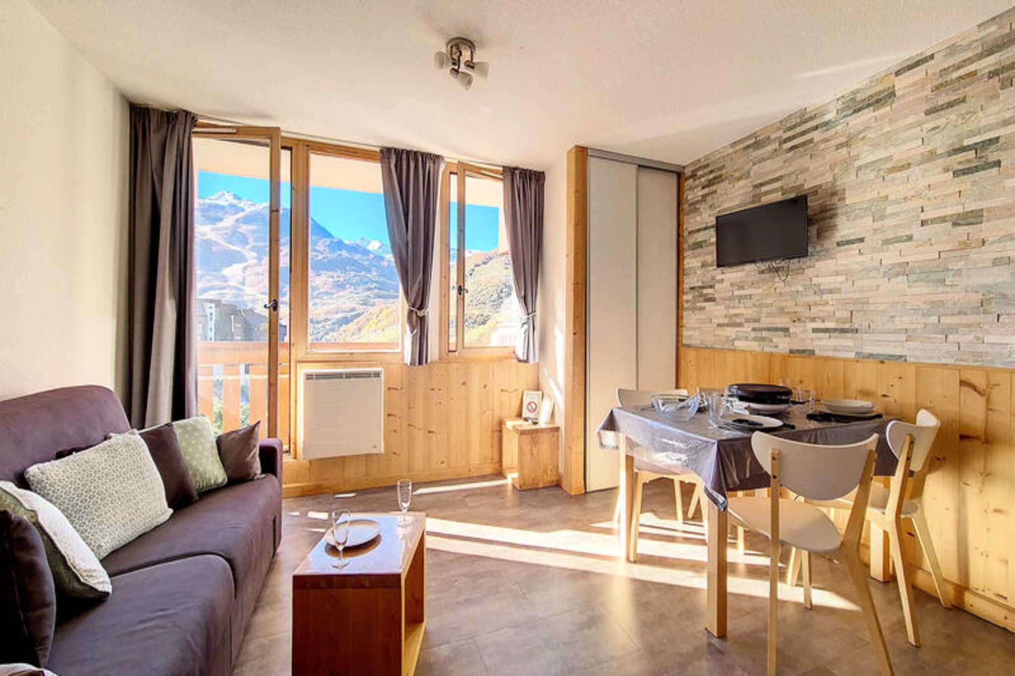 Above the bustling Bruyères district, this stylish studio apartment offers a cozy retreat for up to four guests, blending modern comfort with alpine charm. Situated on the 7th floor, the south-facing balcony opens up to breathtaking views of the slopes, inviting you to soak in the serenity of the mountains while being just steps away from the vibrant heart of the district. Whether you're here for skiing adventures or a summer escape, this residence promises an unforgettable stay. \n\nThe apartment has been beautifully renovated and features a smart layout designed for relaxation and convenience. The living room includes a comfortable double sofa bed and a flat-screen television, perfect for unwinding after a day outdoors. A separate sleeping alcove, cleverly tucked away behind a sliding door, offers two single bunk beds, providing privacy and comfort for families or small groups. The kitchen is fully equipped with modern appliances, including a Senseo coffee machine, microwave/grill, and dishwasher, making meal preparation a breeze. The bathroom is sleek and functional, complete with a shower and toilet. Laminate flooring throughout adds a touch of elegance to the space. \n\nStep outside, and you'll find yourself in the lively Bruyères district, home to a variety of restaurants, shops, and entertainment options. From the ski school and toboggan run to the water park and wellness center, everything you need is within walking distance. Families will appreciate the children's playground, while cinema lovers can enjoy a cozy evening at the local theater. For those seeking adventure, the slopes are right at your doorstep, offering direct access to world-class skiing. \n\nWhether you're drawn by the thrill of the slopes or the charm of the alpine village, this studio is your gateway to a memorable mountain getaway. With its prime location, thoughtful amenities, and stunning views, it’s a perfect choice for couples, families, or friends looking to experience the magic of the French Alps.