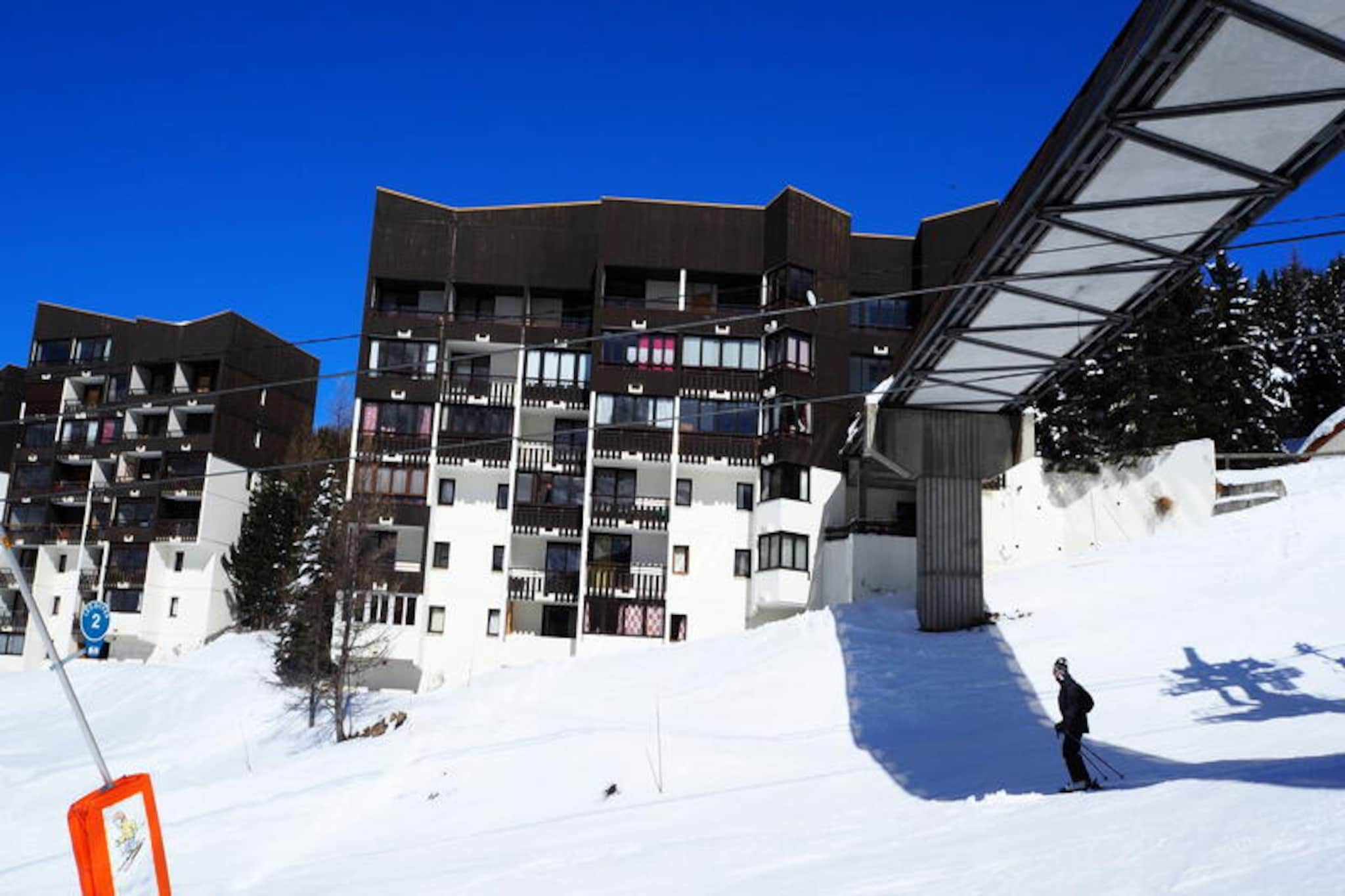 In the heart of Les Menuires, where the majestic Alps create a breathtaking backdrop, this charming studio apartment offers a cozy retreat for those seeking adventure and relaxation. Situated in the Sorbier residence at Place des Bouquetins, its ski-in/ski-out access ensures that your alpine experience begins the moment you step outside. Whether you’re here to carve through pristine slopes or explore the lively atmosphere of the Bruyères district, this property places you at the center of it all. The enclosed southwest-facing balcony invites you to soak in the afternoon sun while enjoying views of the surrounding peaks. \n\nDesigned for up to four guests, the apartment features a thoughtful layout with a living area equipped with a single sofa bed and pull-out single bed, as well as a cozy cabin with two single bunk beds. The kitchen is fully equipped with modern appliances, including a microwave, dishwasher, coffee maker, and toaster, making it easy to prepare meals after a day of adventure. The bathroom includes a bathtub for relaxing soaks, while laminate flooring throughout adds a touch of warmth and comfort. Free Wi-Fi ensures you stay connected, and the residence’s elevator provides convenient access. Please note, pets are not allowed, and the upper bunk is not suitable for children under six years old. \n\nJust steps away, the pedestrian bridge connects you to the vibrant Bruyères district, where you’ll find a variety of restaurants, shops, a cinema, a water park, and a wellness center. Families will appreciate the nearby ski school, toboggan run, and children’s playground, while adventurers can explore the extensive slopes and trails of Les Trois Vallées. With its prime location and welcoming ambiance, this apartment is the perfect base for creating unforgettable alpine memories.