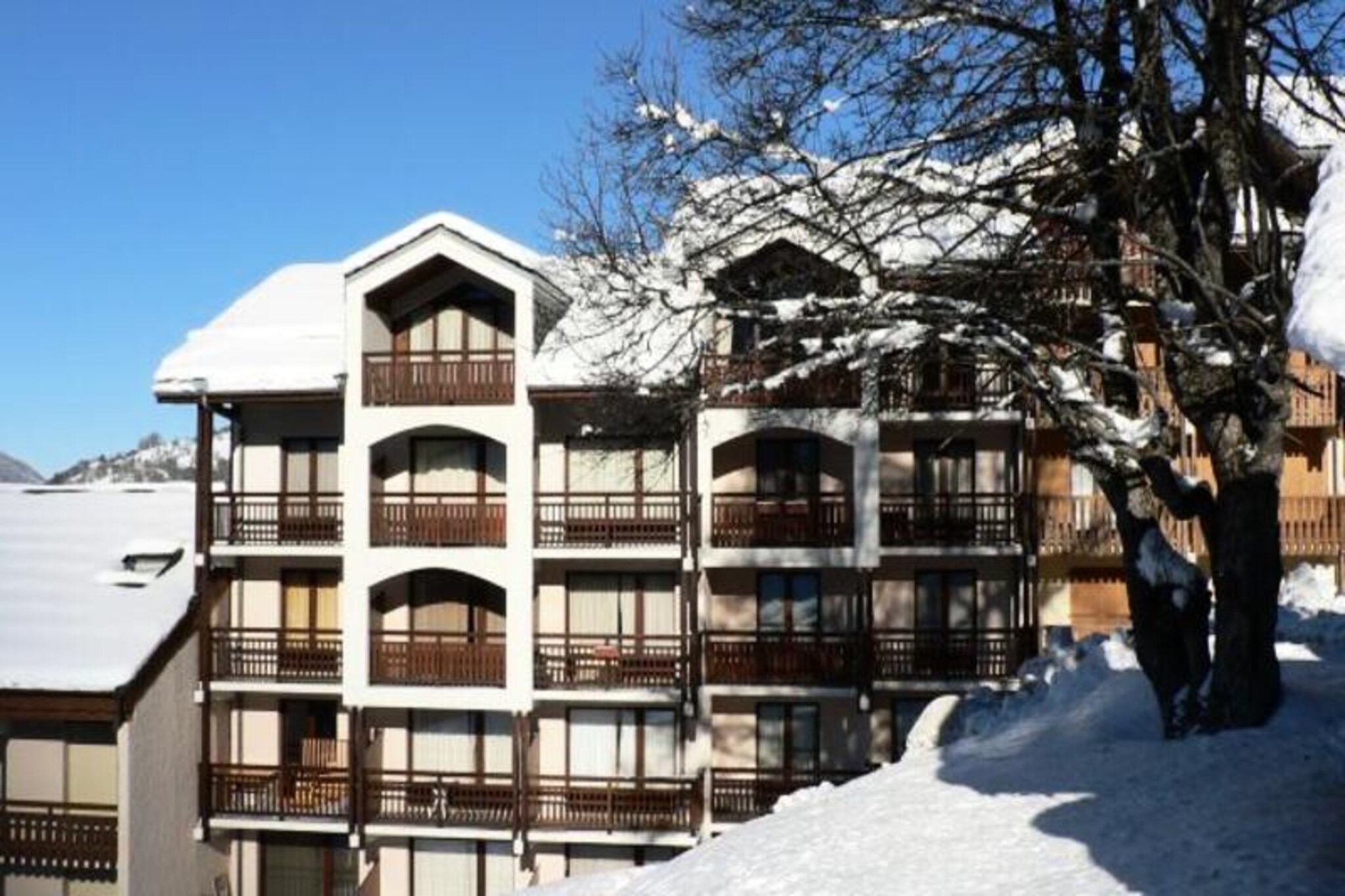 In the charming Grangeraies district of Saint-Martin-de-Belleville, this inviting alpine apartment offers a cozy retreat for ski enthusiasts and nature lovers alike. With the Saint Martin 1 gondola lift just a two-minute walk away, you’ll have direct access to the renowned 3 Valleys ski area, one of the largest and most celebrated in the world. Whether you’re here for thrilling winter sports or tranquil summer hikes, the picturesque surroundings set the stage for unforgettable moments in the French Alps. The residence is conveniently located near shops, ski schools, and essential services, ensuring everything you need is within easy reach. The village center is just a five-minute stroll, offering a delightful mix of local charm and amenities.
Inside, the apartment spans 45m² and features a thoughtful layout designed to accommodate up to six guests. The upper level includes a bedroom with three single beds and a cozy alcove with one single bed, while the living room provides additional sleeping space with a double sofa bed. The fully equipped kitchen invites you to prepare hearty meals after a day of adventure, complete with modern appliances such as an oven, microwave, refrigerator, and dishwasher. Relax in the comfortable living area with a television or step out onto the south/west-facing balcony to soak in the alpine views. The apartment also includes a bathroom with a bathtub, separate WC, and a ski locker for added convenience.
In winter, guests staying for seven nights or more enjoy complimentary amenities like bed linen, towels, and tea towels, making your stay even more comfortable. The residence’s tranquil setting, combined with its proximity to world-class skiing and local attractions, makes it an ideal choice for families, couples, or groups of friends seeking a memorable alpine getaway. Whether you’re exploring the slopes, savoring regional cuisine, or simply unwinding in the serene mountain atmosphere, this property offers the perfect base for your adventures.