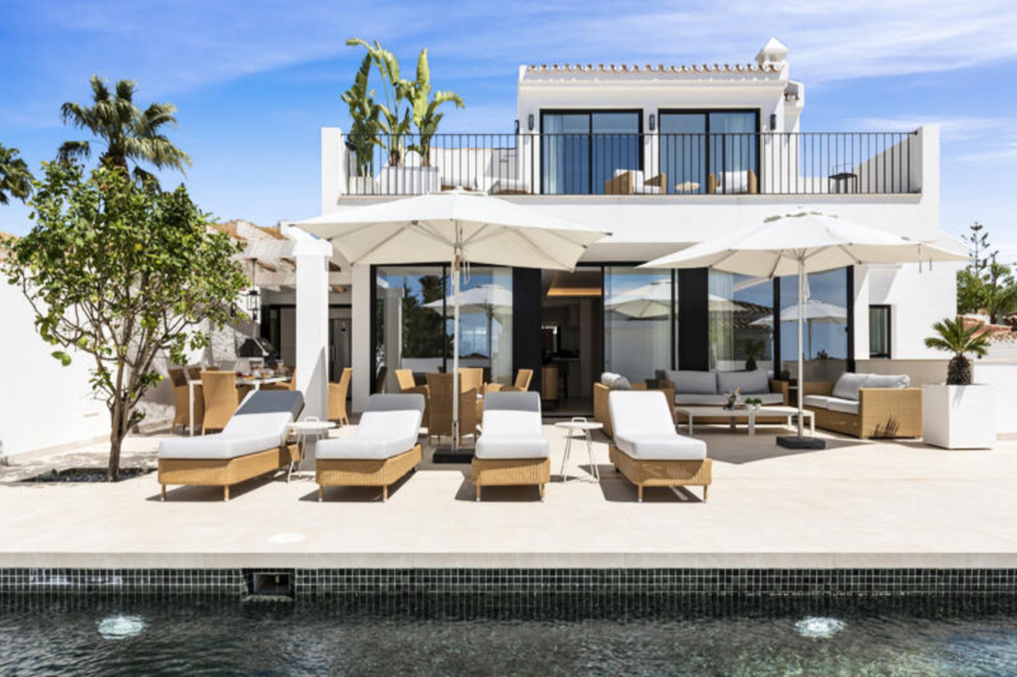 In the serene neighborhood of El Rosario, Marbella, this luxurious beach villa offers a perfect blend of modern elegance and Mediterranean charm. Recently renovated, the villa boasts a sleek interior design that radiates sophistication, making it an ideal retreat for those seeking tranquility and style. Just a 5-minute walk from one of the finest beaches on the Costa del Sol, and close to the renowned Nikki Beach Club and La Cabane, this property places you in the heart of Marbella’s most sought-after coastal experiences.
Step inside to discover a spacious open-plan living area, where large sliding doors seamlessly connect the indoors with the outdoors. The living room is tastefully decorated, creating a cozy ambiance for family gatherings or evenings with friends. The fully equipped modern kitchen integrates effortlessly into the space, opening onto a private terrace where you can bask in the Mediterranean sun. Upstairs, the master bedroom features a private balcony with breathtaking views of the sea, while the basement houses four additional double bedrooms, each with en-suite bathrooms and access to a terrace that connects to the main outdoor area.
Outside, the villa truly shines. The terrace includes a private heated swimming pool and jacuzzi, perfect for year-round relaxation. A barbecue area invites you to enjoy al fresco dining, while the partially covered terrace with plush seating offers a serene spot to unwind under the stars. Additional amenities such as a fully equipped laundry room, private parking, and a state-of-the-art security system ensure your stay is as comfortable as it is secure.
With Marbella town center just 5 km away and easy access to iconic destinations like Puerto Banus, Fuengirola, and Gibraltar, this villa is perfectly positioned for exploring the best of the Costa del Sol. Whether you’re lounging by the pool, strolling to the beach, or savoring the vibrant local culture, this property promises an unforgettable holiday experience.