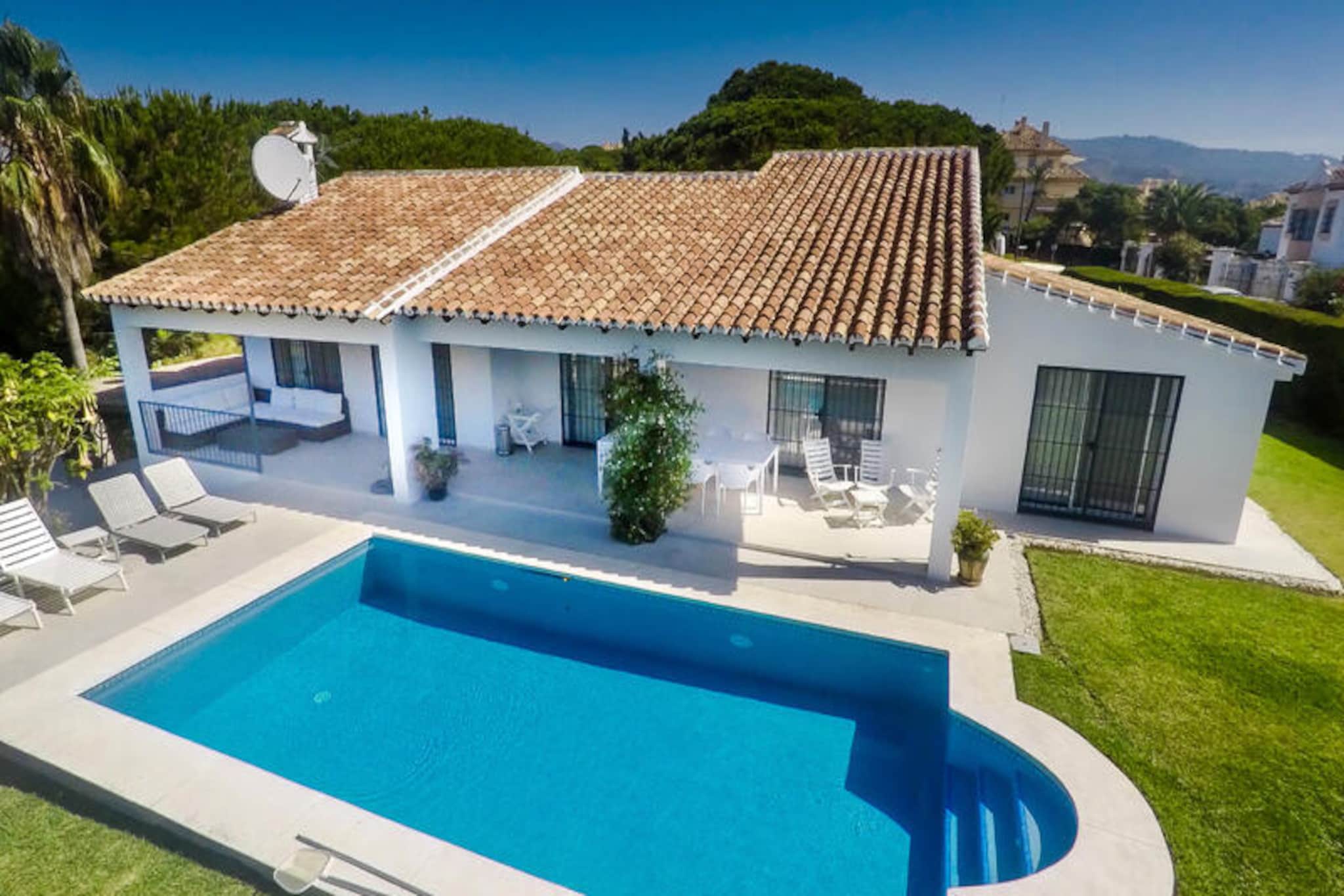 Bask in the warmth of the Andalusian sun at this charming single-story villa, a serene retreat nestled in a quiet, family-friendly neighborhood near Marbella. With its lush, beautifully maintained garden and private south-facing pool, this villa invites you to unwind and soak up the Mediterranean lifestyle. Whether you’re lounging by the pool, dining al fresco on the covered terrace, or enjoying a siesta on the comfortable outdoor sofa, every moment here feels like a slice of paradise. \n\nInside, the villa comfortably accommodates up to ten guests across four bedrooms. Three feature cozy double beds, while the fourth offers two fun bunk beds, perfect for children or groups. Built in the 1970s, the villa exudes a nostalgic charm while offering modern conveniences like free Wi-Fi, central air conditioning, and a fully equipped kitchen. The gas barbecue is ideal for preparing delicious meals to enjoy under the stars, making it a perfect choice for families or groups of friends seeking comfort and togetherness.\n\nJust a short three-minute drive away, you’ll find a variety of shops, restaurants, and bars, as well as a large supermarket for all your needs. The famous Nikki Beach Marbella beach club is also nearby, offering a luxurious seaside experience. For thrill-seekers, Aventura Amazonia provides an exciting day of ziplining and climbing adventures. The vibrant Marbella town center, with its Salvador Dalí sculptures, sandy beaches, and the picturesque Plaza de las Naranjos, is just a ten-minute drive away, offering a mix of culture, history, and entertainment.\n\nWhether you’re looking to relax by the pool, explore Marbella’s rich heritage, or indulge in the area’s culinary delights, this villa is the perfect base for an unforgettable holiday. With sunshine, comfort, and adventure at your doorstep, your Andalusian escape awaits.