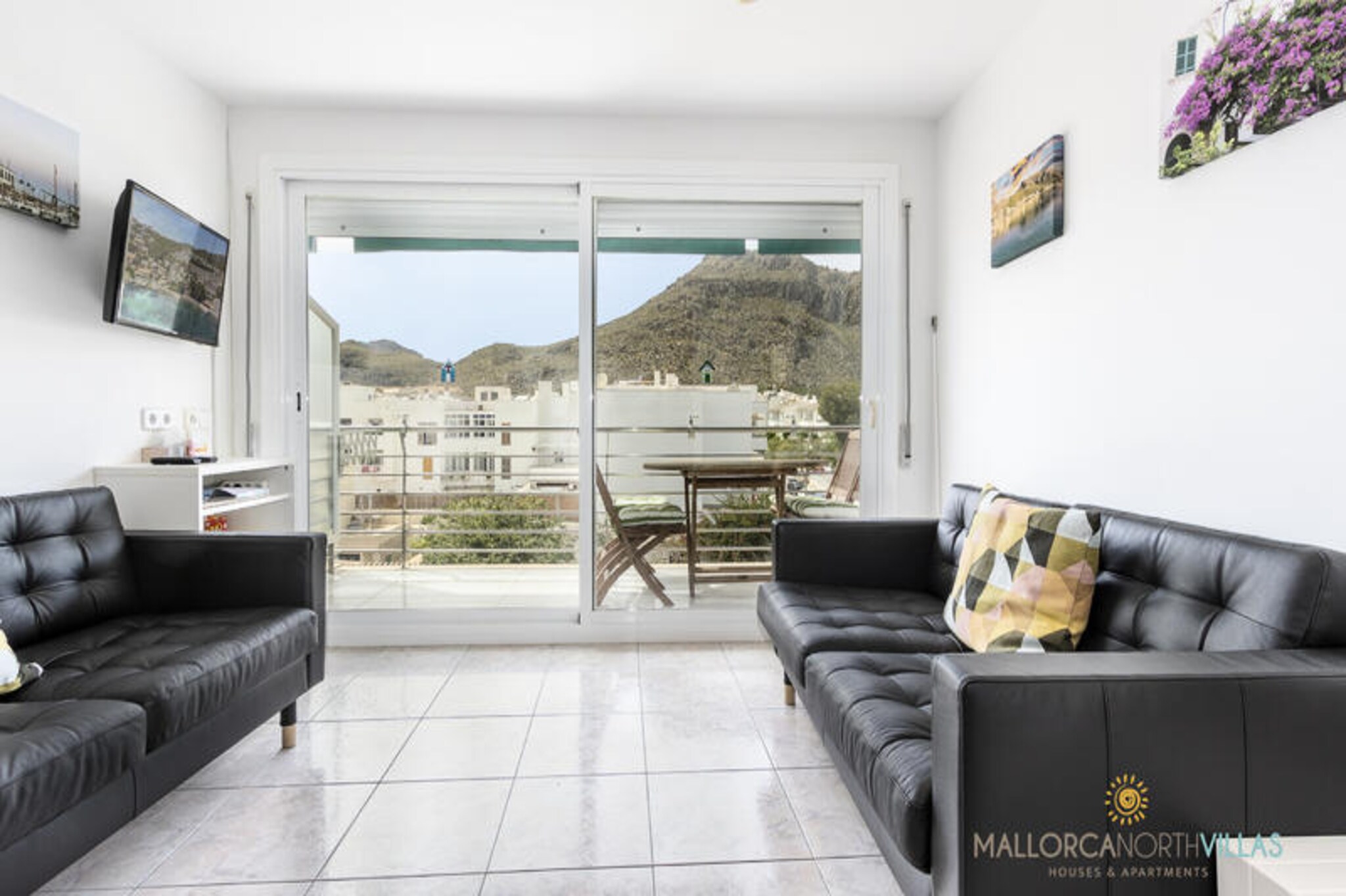 In the heart of Puerto de Pollensa, where the mountains meet the sea, this bright and welcoming apartment invites you to experience the serene beauty of northern Mallorca. Just a minute's walk from the sandy shores, this is the perfect retreat for families or couples seeking a blend of relaxation and adventure. Wake up to the soft Mediterranean breeze and enjoy your morning coffee on the private terrace, with stunning views of the Tramuntana mountains as your backdrop. \n\nInside, the 64 m² apartment offers a thoughtfully designed space with two comfortable double bedrooms and a modern bathroom. The fully equipped kitchen, complete with a refrigerator, oven, microwave, and coffee maker, makes meal preparation a breeze, while the cozy living area with free Wi-Fi and TV ensures you feel right at home. Air conditioning and heating provide year-round comfort, and the terrace with a grill is perfect for al fresco dining under the stars. \n\nStep outside, and you'll find yourself surrounded by the charm of Puerto de Pollensa. Stroll to nearby restaurants, shops, and supermarkets, or explore the pristine beaches and hidden rocky coves just moments away. For nature enthusiasts, the S'Albufera Natural Park is only 18 km away, offering a haven for birdwatching and hiking. Golf lovers will appreciate the course just 12 km from the property, while public parking nearby ensures convenience throughout your stay. \n\nWhether you're soaking up the sun on the beach, savoring local cuisine, or exploring the island's natural wonders, this apartment offers the perfect base for an unforgettable Mallorcan getaway. Book now and let the magic of Puerto de Pollensa captivate you.