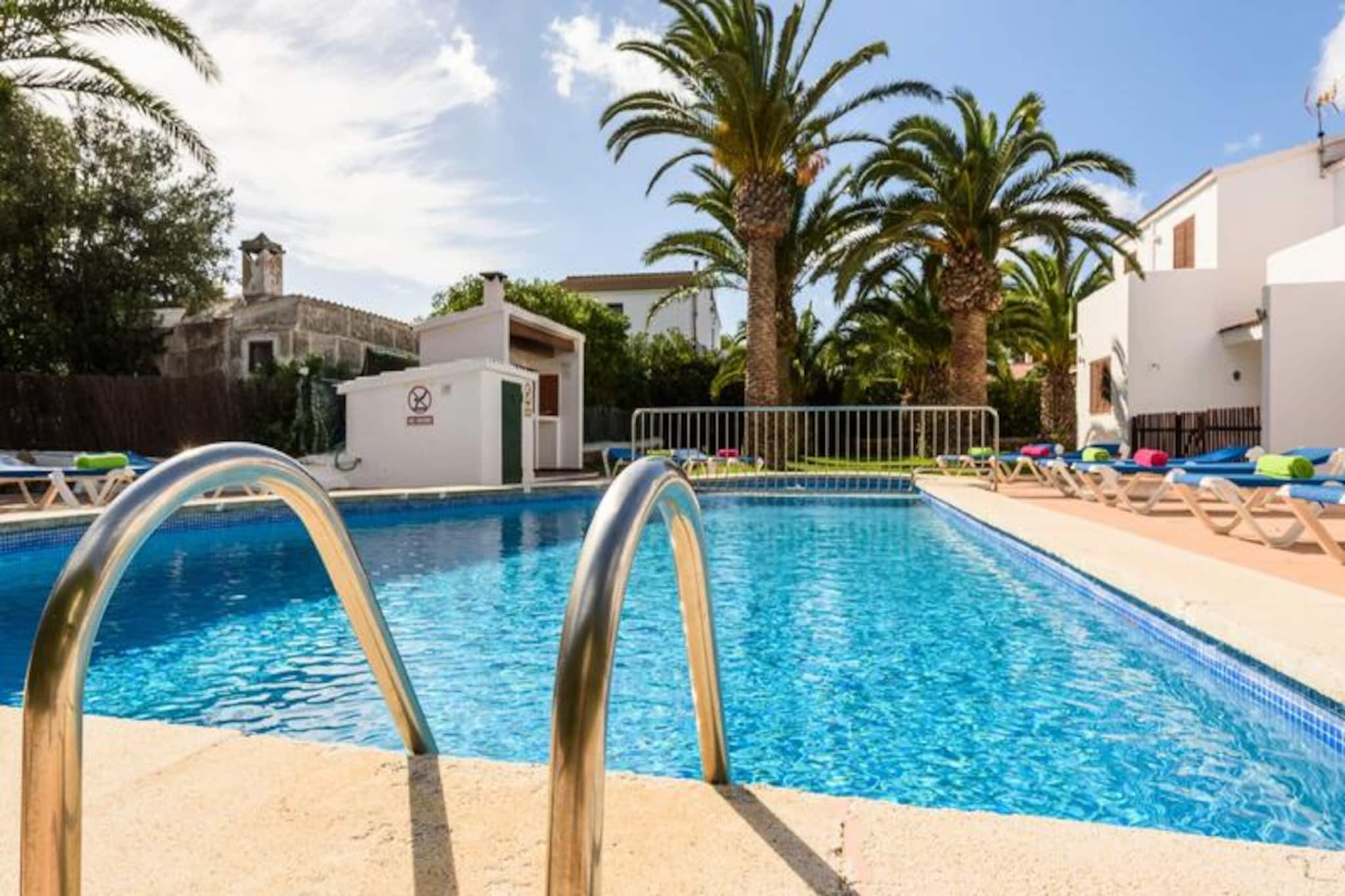 Bask in the Mediterranean charm of this bright and welcoming apartment in Cala Blanca, Menorca. Perfectly suited for a family of four, this tranquil retreat offers a serene escape surrounded by lush gardens and the sparkling communal pool. Whether you're seeking relaxation or adventure, this property promises a memorable stay on this enchanting Balearic island.
Step inside and discover a thoughtfully designed 60 m² space filled with natural light. The apartment features two cozy bedrooms, a comfortable living area with air conditioning, and a fully equipped separate kitchen with everything you need to prepare delicious meals, from a gas stove to a coffee maker. The private terrace invites you to enjoy al fresco dining or unwind with a good book while taking in views of the garden and pool. Modern amenities such as Wi-Fi, satellite TV, and a washing machine ensure your stay is as convenient as it is enjoyable.
Located just 900 meters from the golden sands of Cala Santandria beach, this apartment is ideally situated for exploring the island’s natural beauty. Stroll to nearby restaurants like Sa Nacre Santandria or venture further to Cala Blanca for a variety of dining options, including Nautilus and Jenny's. The historic town of Ciutadella de Menorca is only 7 km away, offering charming streets, local markets, and a glimpse into Menorca’s rich heritage. For family fun, AquaRock water park is just a short drive away.
Whether you're soaking up the sun by the pool, exploring Menorca's pristine beaches, or indulging in local cuisine, this Cala Blanca apartment is your gateway to an unforgettable Mediterranean getaway.