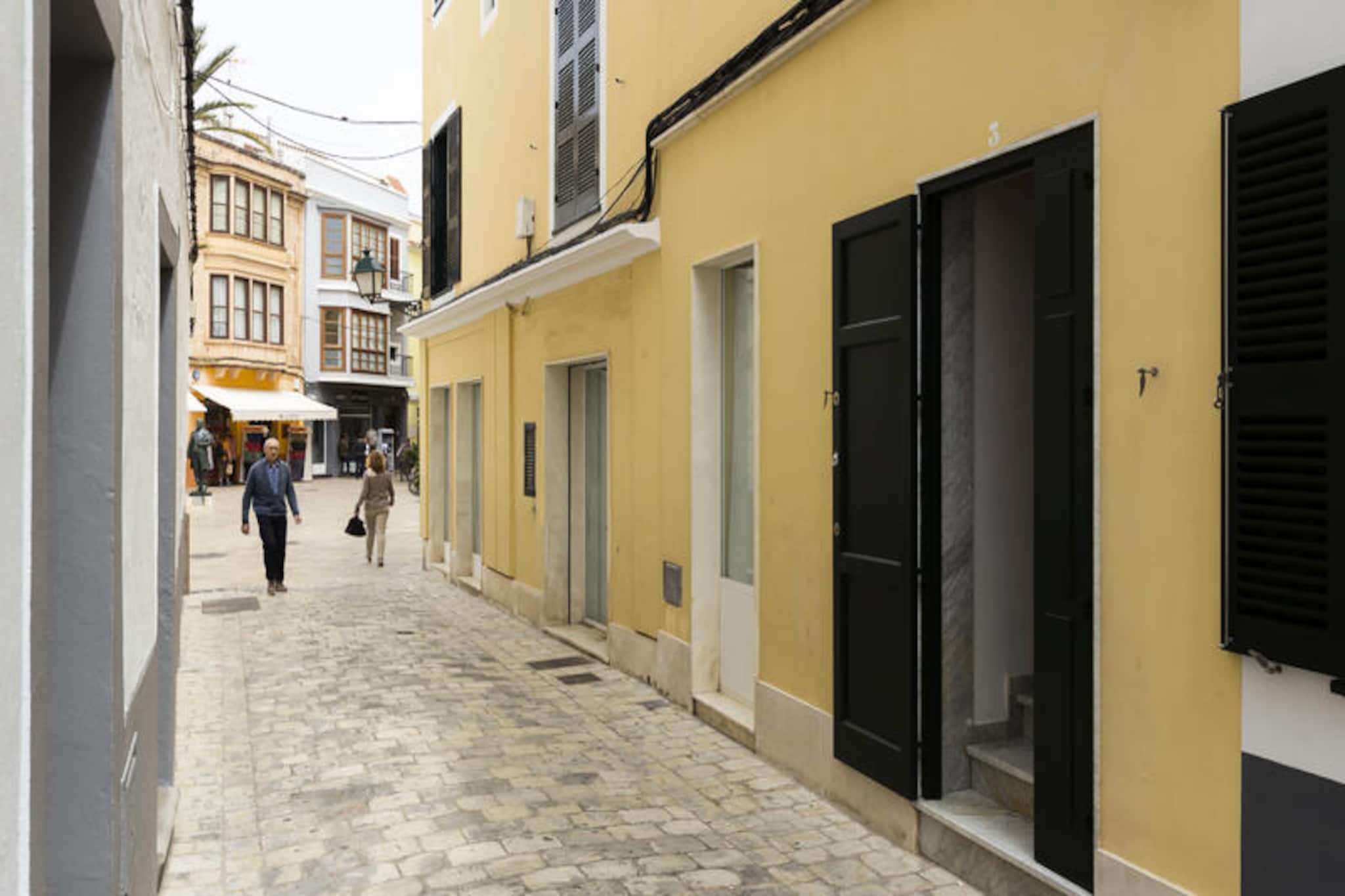 In the enchanting streets of Ciutadella de Menorca, this elegant holiday home invites you to experience the charm of the Mediterranean in a setting rich with history and coastal beauty. Perfectly situated in the heart of the city, this property offers a harmonious blend of convenience and tranquility, making it an ideal retreat for families and groups seeking a memorable island getaway. Imagine waking up to the gentle sea breeze and stepping out onto your private terrace to soak in the vibrant atmosphere of Menorca’s cultural hub. \n\nSpanning 150 m², the house is tastefully furnished with a touch of local flair, providing a comfortable and welcoming space for up to eight guests. With four spacious bedrooms, a fully equipped ceramic-cooktop kitchen, and modern amenities such as Wi-Fi, television, and five fans to keep you cool, every detail has been thoughtfully designed for your comfort. The terrace is perfect for enjoying al fresco meals or unwinding with a glass of wine after a day of exploration. Additional conveniences like a washing machine, iron, and hairdryer ensure a hassle-free stay. \n\nStep outside and immerse yourself in the vibrant life of Ciutadella. From charming cafes and boutique shops to historical landmarks like the Cathedral of Menorca, everything is within easy reach. The nearby harbor offers stunning views and opportunities for boat excursions, while the pristine beaches of Menorca are just a short drive away. Whether you’re strolling through the old town’s cobbled streets or discovering hidden coves along the coast, the island’s natural and cultural treasures await. \n\nChoose this property for an unforgettable holiday where relaxation meets discovery, and let the timeless allure of Menorca create lasting memories for you and your loved ones.