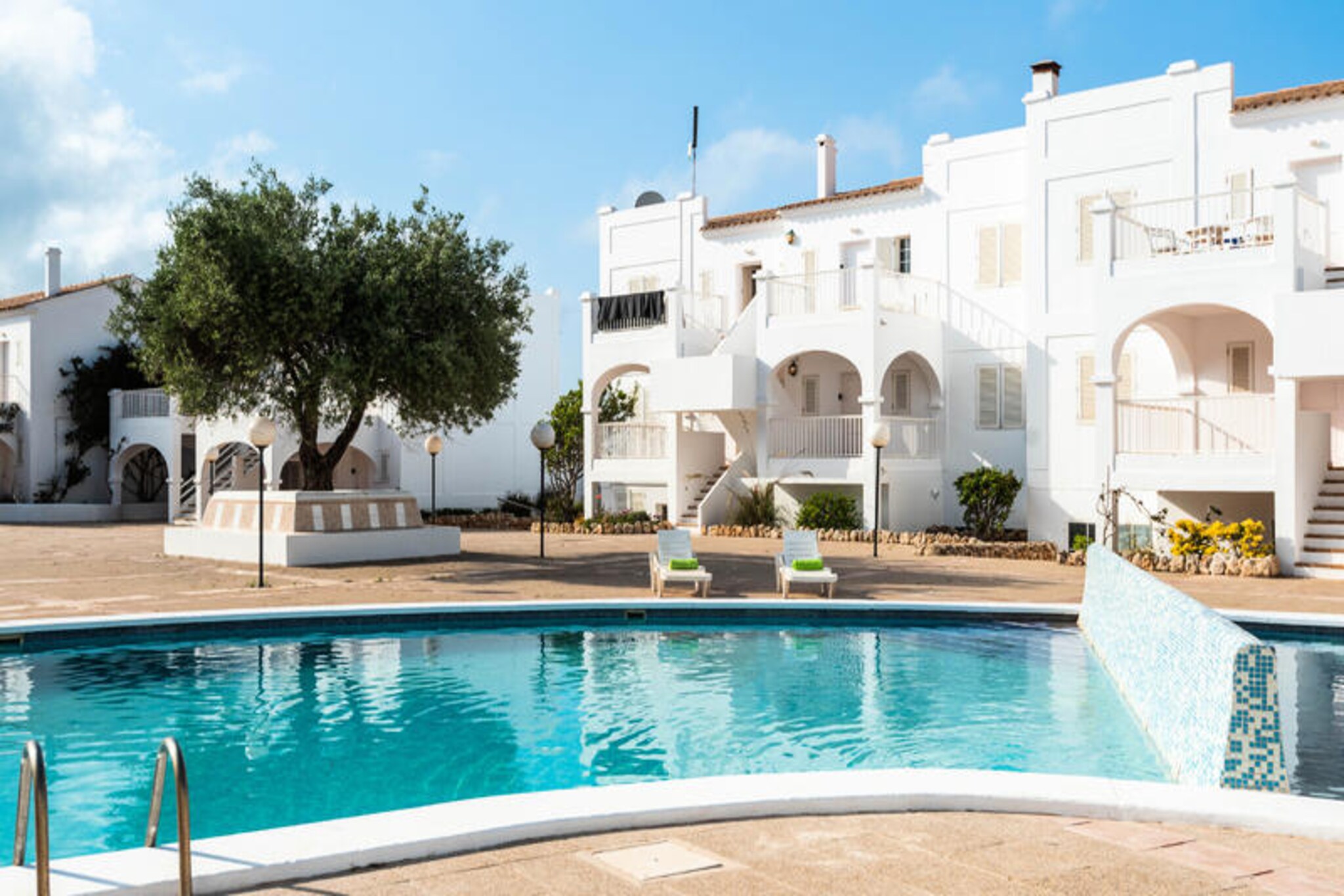 Step into a Mediterranean paradise where the turquoise waters of Arenal d’en Castell meet the golden sands of its pristine beach. This charming apartment offers a serene escape for couples or small families seeking the perfect blend of comfort and coastal beauty. Located just moments away from the vibrant heart of the town, you’ll find yourself surrounded by the gentle rhythm of the sea and the warm embrace of the Spanish sun.
The apartment is thoughtfully designed to accommodate up to four guests, featuring a cozy bedroom and a bright, open-plan living space that invites relaxation. The fully equipped kitchen, complete with a ceramic hob, refrigerator, microwave, and dishwasher, makes it easy to prepare meals to enjoy on the private 10 m² terrace. Modern amenities such as air conditioning, Wi-Fi, a washing machine, and a shared swimming pool ensure a comfortable and carefree stay. Whether you’re sipping your morning coffee on the terrace or unwinding in the living room with the TV, every detail has been considered to make your holiday unforgettable.
Beyond the apartment, the sandy shores of Playa Arenal d’en Castell are just 200 meters away, perfect for sunbathing or a refreshing swim. For those who enjoy a more rugged coastline, the rocky beach is equally close. The area is dotted with charming restaurants, cafes, and a supermarket, all within walking distance. Golf enthusiasts can tee off at the nearby Son Park Golf course, while those seeking a cultural touch can explore the historic streets of Mahón, just 15 km away.
Whether you’re here to bask in the sun, explore the island’s natural beauty, or simply relax by the pool, this apartment is your gateway to the enchanting Menorcan lifestyle. Let the gentle sea breeze and the island’s charm create memories you’ll treasure forever.