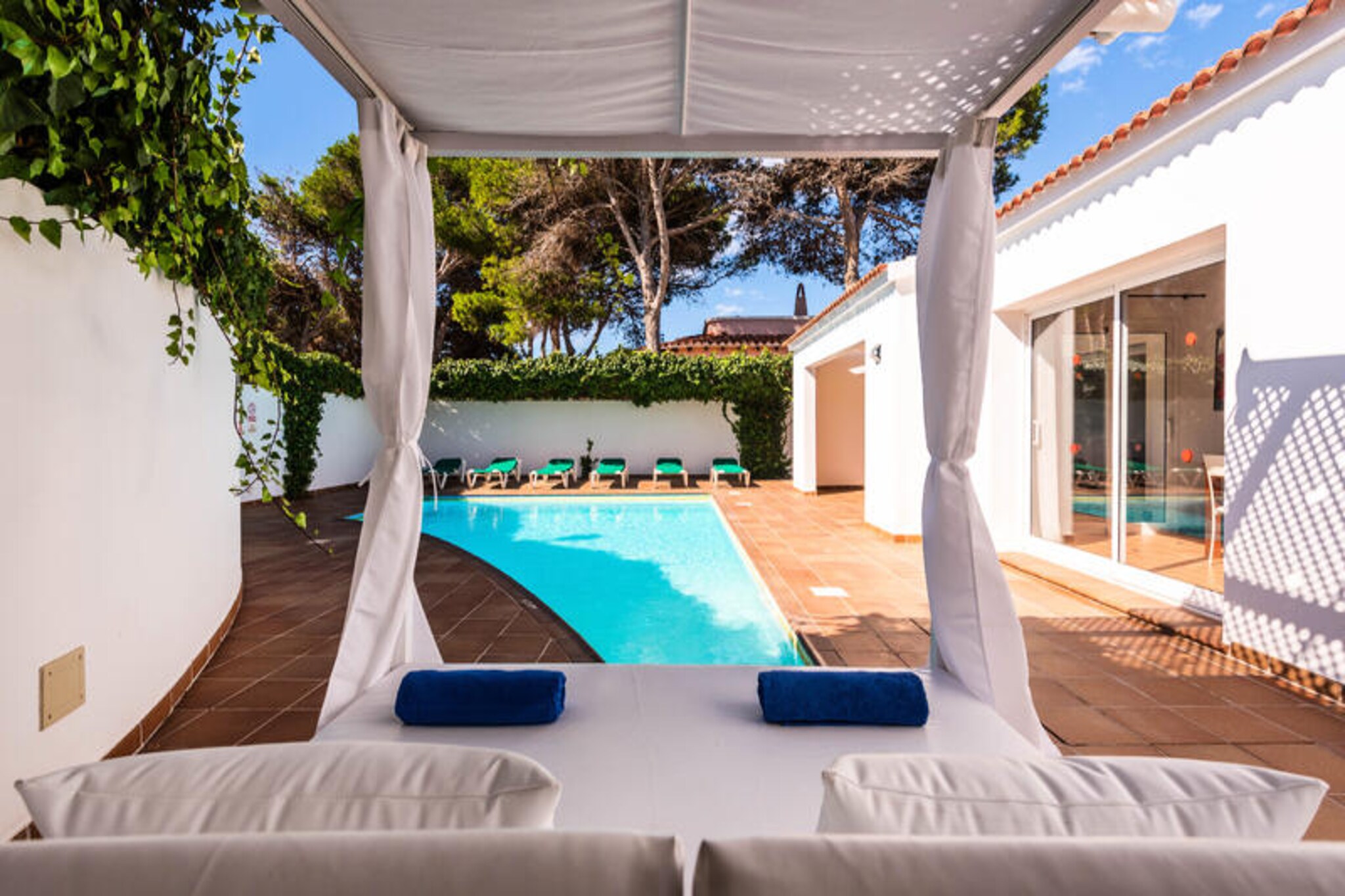 A serene escape awaits in Cala'n Bosch, where this modern family-friendly villa offers the perfect blend of comfort and Mediterranean charm just 600 meters from the sandy beach. Imagine waking up to the gentle sea breeze, stepping onto your private terrace overlooking the sparkling 8x4 meter swimming pool, and enjoying the lush garden adorned with outdoor furniture, a barbecue, and a luxurious Balinese bed for ultimate relaxation. This property invites you to unwind in style while embracing the beauty of Menorca’s coastline. \n\nInside, the villa is thoughtfully designed to ensure year-round comfort with air conditioning and heating throughout. The spacious layout includes four bedrooms and three bathrooms, two with showers and one with a bathtub, providing ample privacy for families or groups. The separate kitchen is fully equipped with modern appliances such as a refrigerator, freezer, washing machine, dishwasher, microwave, and coffee maker, making meal preparation a breeze. Wi-Fi and a television with Spanish and English channels add convenience and entertainment to your stay. \n\nBeyond the villa, Cala'n Bosch offers a vibrant yet tranquil atmosphere. Stroll to the nearby beach, explore the marina with its charming restaurants and shops, or venture further to discover Menorca’s natural wonders, from hidden coves to scenic hiking trails. The villa’s location ensures easy access to both relaxation and adventure, making it an ideal base for exploring this stunning island. \n\nWhether you’re seeking a peaceful retreat or an active seaside holiday, this villa provides the perfect setting to create unforgettable memories with loved ones. Let the sun-soaked days and starry nights of Cala'n Bosch rejuvenate your spirit and inspire your next getaway.