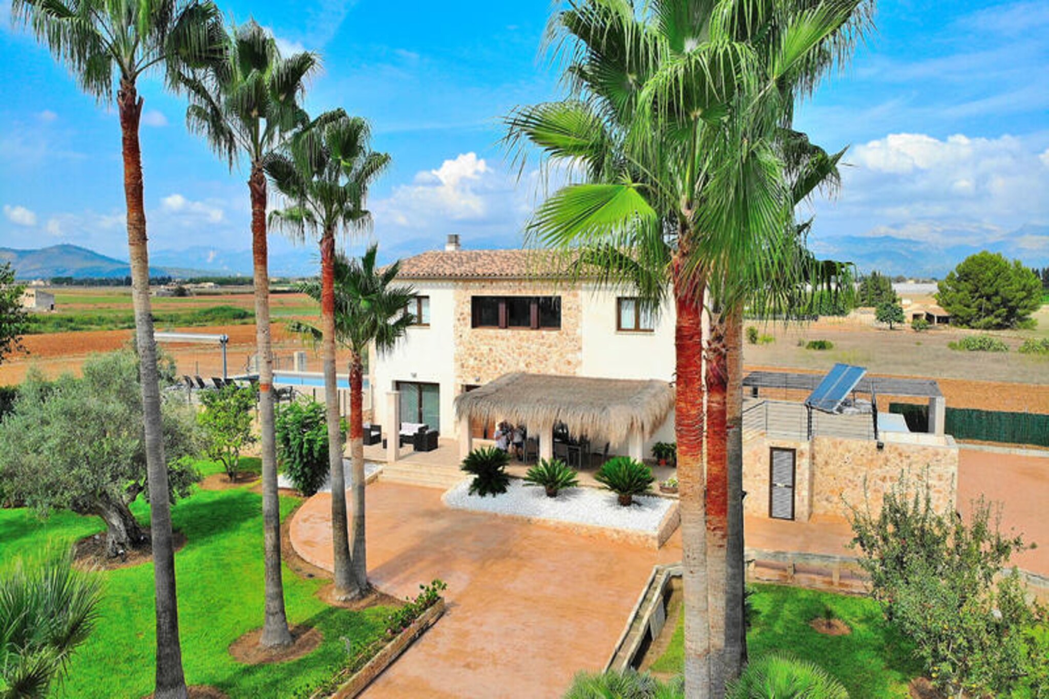 In the heart of Mallorca’s serene countryside, this majestic villa offers an unparalleled retreat where luxury meets Mediterranean charm. Surrounded by lush greenery and idyllic landscapes, the property invites you to unwind in a haven of tranquility, just a short drive from Muro’s cobbled streets and pristine beaches. Whether you’re seeking a peaceful escape or a base to explore the island’s treasures, this villa promises an unforgettable stay. \n\nSpanning 250 m², the villa comfortably accommodates up to eight guests across four spacious bedrooms, each with its own en-suite bathroom. Three of the bedrooms are located upstairs, providing privacy and stunning views, while the ground floor features a fourth bedroom, a bright and fully equipped kitchen, and an elegant living/dining area. The villa’s modern design and high-quality amenities ensure your comfort, while the separate toilet adds convenience for larger groups. \n\nStep outside to discover the villa’s crowning jewel: a beautifully landscaped garden with a fenced swimming pool, perfect for families with children. Relax on the sun loungers, fire up the barbecue for al fresco dining, or simply savor the Mediterranean sunshine on the terrace. The outdoor space is thoughtfully designed with comfortable furniture, making it an ideal spot to enjoy the company of loved ones amidst breathtaking surroundings. \n\nLocated near the charming village of Muro, the villa is perfectly positioned to explore Mallorca’s rich culture and natural beauty. From golden beaches to vibrant markets and exquisite local cuisine, every corner of the island offers something special. Whether you’re basking by the pool or venturing out to discover Mallorca’s hidden gems, this villa is your gateway to an extraordinary holiday experience.