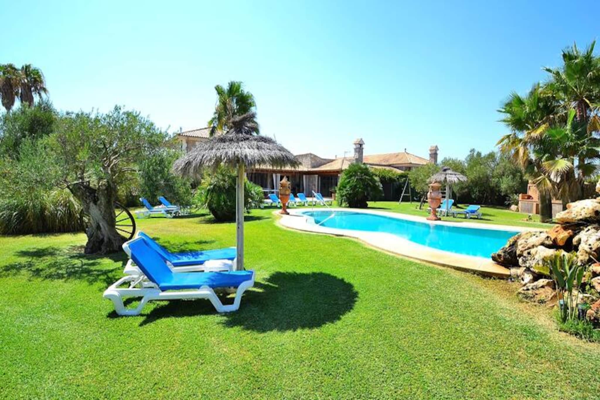In the sun-drenched northern region of Mallorca, this expansive villa offers a serene escape just minutes from the golden sands of Can Picafort. Surrounded by lush Mediterranean landscapes, this property invites you to unwind in its tranquil outdoor spaces, where the sparkling pool with a cascading waterfall becomes the centerpiece of relaxation. Whether you're lounging under the warm Mallorcan sun or enjoying a barbecue with loved ones, this villa promises unforgettable moments in a picturesque setting. With its proximity to the vibrant coastal village of Can Picafort, you can easily explore pristine beaches, charming local markets, and a lively dining scene. \n\nInside, the villa is designed for comfort and convenience, accommodating up to ten guests across six spacious bedrooms. Two rooms feature cozy double beds, while the remaining four offer twin beds, perfect for families or groups of friends. The four bathrooms, including one with a shower and three with bathtubs, ensure ample space for everyone. The large living and dining area is ideal for gathering together, while the fully equipped kitchen connects to a second living room with a fireplace, creating a warm and inviting atmosphere. Modern amenities and thoughtful touches make this villa a true home away from home. \n\nBeyond the villa, the outdoor area is a haven for leisure and fun. Dive into the pool, relax on sun loungers, or challenge friends to a game of beach volleyball. Children will love the dedicated play area, while adults can savor evenings by the barbecue under the starlit sky. The villa’s location between Muro and Can Picafort offers easy access to nearby attractions, including stunning beaches, nature reserves, and cultural landmarks. \n\nThis villa is more than just a place to stay; it’s a gateway to the vibrant spirit of Mallorca. Whether you're seeking adventure or tranquility, this property provides the perfect base for creating cherished memories on this enchanting island.