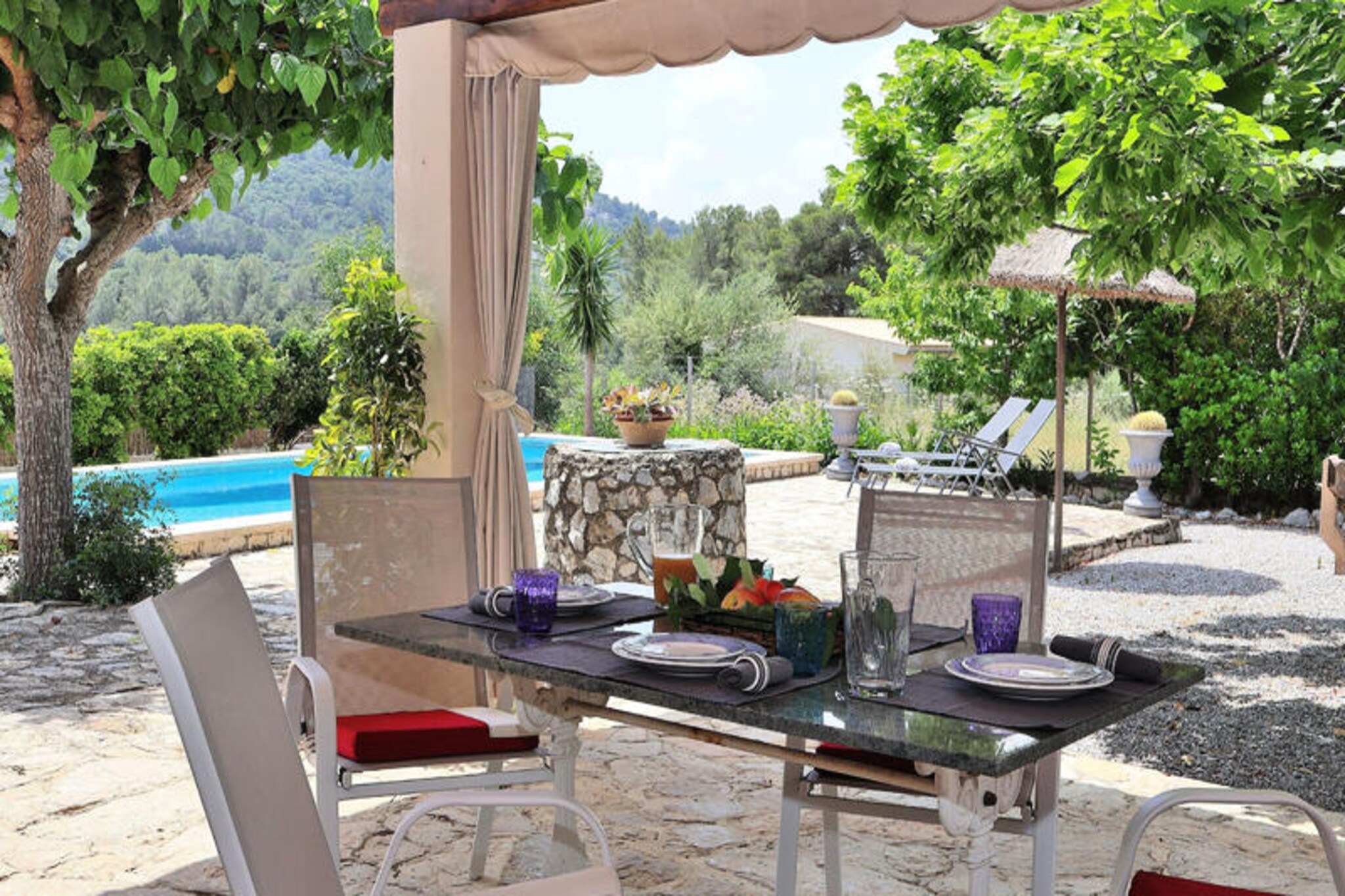 Amid the serene countryside of Mallorca, this enchanting finca offers a private retreat at the foot of the Sierra de Tramuntana mountains. Surrounded by 7,000 square meters of lush Mediterranean gardens, this property is a haven for relaxation and tranquility. Located between Pollensa and Sa Pobla, it provides easy access to the charming cobbled streets of Pollensa, just 6 km away, and the vibrant local markets and restaurants of Sa Pobla. Whether you’re seeking solitude or cultural exploration, this romantic hideaway is perfectly situated to offer both. \n\nInside, the finca comfortably accommodates up to five guests with two cozy bedrooms—a double room and a second room featuring a single bed and a bunk bed. The living and dining area is thoughtfully designed, blending rustic charm with modern convenience. A fully equipped kitchen, a large dining table, and plush sofas create a welcoming space for shared meals and evening relaxation. Solar panels power the home, ensuring an eco-friendly stay, while amenities like internet access and a TV with DVD/CD player provide modern comforts. \n\nStep outside to discover the partially covered terrace, perfect for al fresco dining or simply soaking in the breathtaking views of the mountains and the sparkling swimming pool. High-quality sun loungers invite you to unwind under the Mallorcan sun, while the outdoor barbecue sets the stage for memorable evenings with family or friends. The meticulously maintained garden, adorned with Mediterranean flora, adds to the finca’s charm and tranquility. \n\nLocated just 8 km from the pristine beaches of Puerto de Alcudia and Puerto de Pollensa, this property offers the best of both worlds—peaceful countryside living and easy access to miles of white sandy shores. Whether you’re exploring the historic streets of Pollensa, hiking the Tramuntana trails, or basking in the sun by the pool, this finca promises an unforgettable Mallorcan escape.