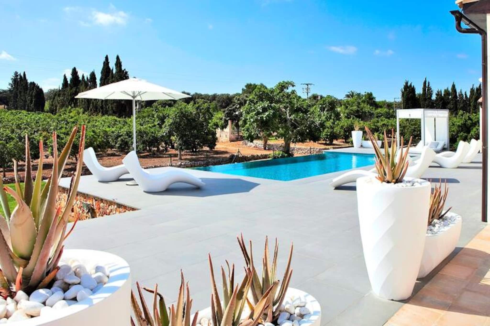 Amidst the serene countryside of Mallorca, this elegant villa, Son Calet, offers a tranquil retreat between the charming villages of Muro and Llubá. Here, the beauty of Mediterranean living unfolds with lush landscapes, golden sunlight, and the promise of relaxation. Whether you’re seeking a peaceful escape or an adventure-filled holiday, this villa invites you to experience the best of both worlds. Its location provides easy access to the authentic charm of Muro, just a 5-minute drive away, and the pristine beaches of Mallorca, only 12 km from your doorstep. \n\nThe villa spans 180 m² and is designed with modern sophistication and impeccable taste. Accommodating up to six guests, it features three beautifully appointed bedrooms—two with double beds and one with twin beds—alongside two stylish bathrooms with showers. The spacious living and dining area is bathed in natural light, creating a warm and inviting atmosphere. The open-plan kitchen seamlessly connects to the dining space, making it ideal for shared meals and moments with loved ones. Every detail of the interior reflects high-quality craftsmanship and thoughtful design, ensuring a comfortable and luxurious stay. \n\nStep outside to discover a 270 m² terrace that embodies the essence of Mediterranean outdoor living. Relax on modern garden furniture, savor meals in the barbecue area, or cool off in the large cascading pool surrounded by lush greenery. This outdoor haven is perfect for soaking up the sun, enjoying leisurely evenings, or simply unwinding in the peaceful surroundings. \n\nWith its proximity to Muro’s cobbled streets, local markets, and exquisite Mallorcan architecture, as well as the nearby beaches, Son Calet is a gateway to the authentic charm of Mallorca. Whether you’re exploring the island’s cultural treasures or indulging in its natural beauty, this villa is the perfect base for creating unforgettable memories.