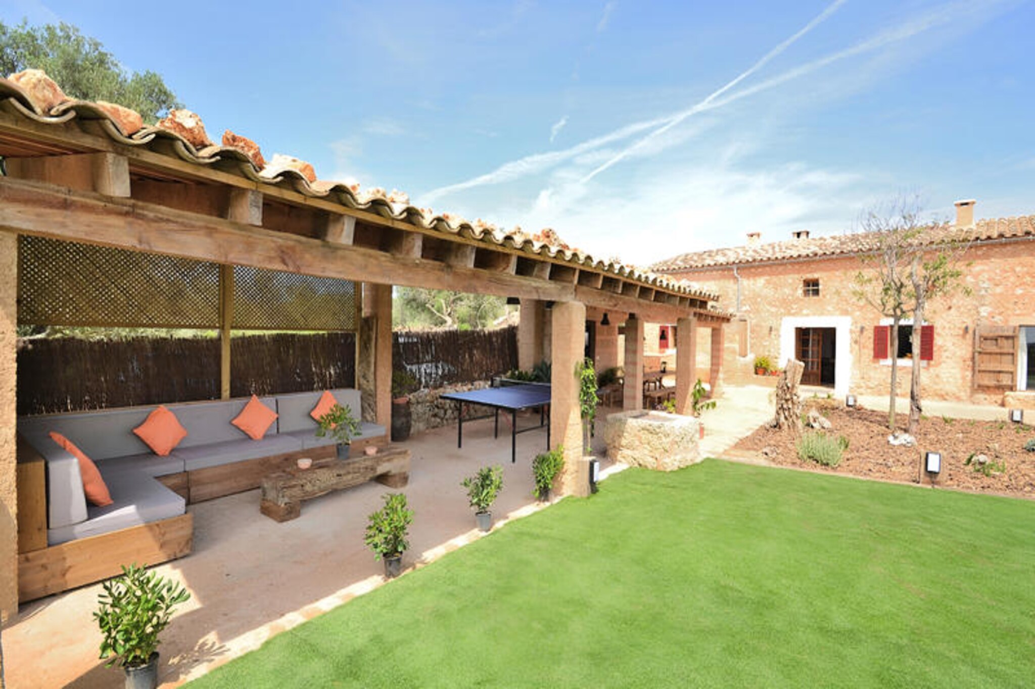 Amidst the serene countryside of Mallorca, this luxurious finca near Llubi invites you to experience the perfect blend of tranquility and indulgence. Surrounded by olive groves and Mediterranean charm, the property offers a peaceful retreat just 3 km from the picturesque village of Llubi, where you can explore quaint cafes, local shops, and traditional restaurants. Whether you’re seeking relaxation or adventure, this finca places you within easy reach of the island’s treasures, including the pristine beaches of Can Picafort and Playa de Muro, just a 15-minute drive away, and the exclusive S'Albufera Marine Reserve. \n\nDesigned to accommodate up to six guests, the finca boasts three beautifully appointed bedrooms—one with a double bed and two with twin beds—alongside two modern bathrooms. The layout ensures comfort and convenience, with one bedroom and bathroom on the ground floor and the remaining upstairs. Air conditioning in all rooms guarantees a cool escape during warm summer days, while a cozy fireplace and central heating provide warmth during winter stays. Powered by solar energy, the property combines luxury with sustainability. The spacious living and dining area features contemporary design, a flat-screen TV, and Wi-Fi, while the fully equipped kitchen caters to all your culinary needs. \n\nStep outside to discover a covered terrace perfect for al fresco dining or lively games of table tennis. The lush garden invites you to unwind on sun loungers or take a refreshing dip in the 3x6 meter swimming pool. Families will appreciate the swing and trampoline, ensuring fun for younger guests. With its idyllic setting and thoughtful amenities, this finca is a haven for relaxation and memorable moments. \n\nWhether you’re exploring the nearby beaches, savoring Mallorcan cuisine, or simply soaking in the peaceful ambiance, this property offers an unparalleled escape into the heart of Mallorca’s beauty. Book your stay and create lasting memories in this enchanting retreat.