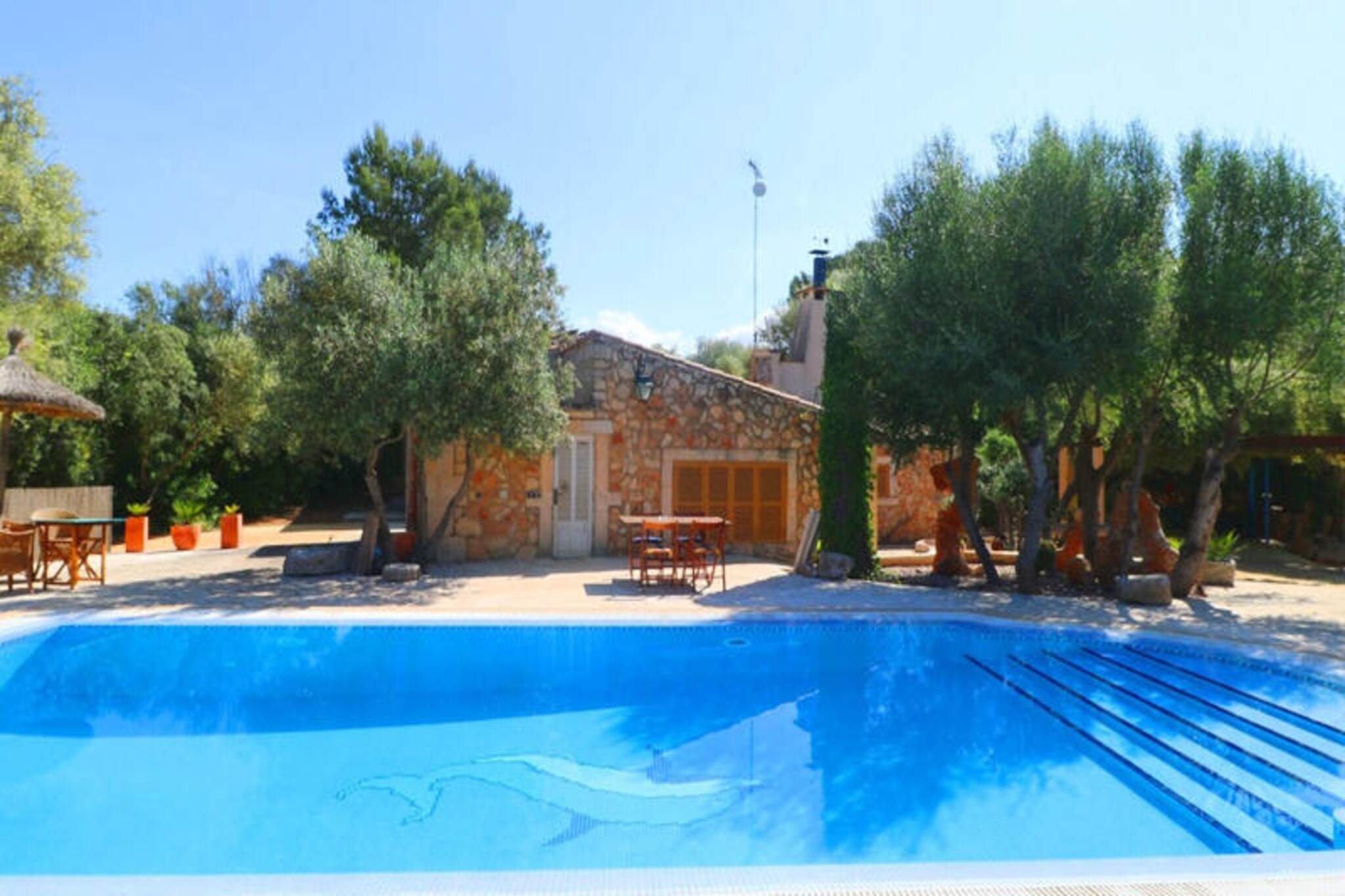 In the heart of Mallorca’s serene countryside near the charming village of Campos, this rustic farmhouse invites you to experience the island’s authentic charm. Surrounded by lush Mediterranean landscapes, this property offers a tranquil retreat where the gentle sounds of nature and the warm island breeze create an idyllic setting for your holiday. Whether you’re seeking relaxation or adventure, this farmhouse is your perfect escape. \n\nStep inside and discover a harmonious blend of traditional Mallorcan architecture and modern comfort. The 120 m² living space is thoughtfully designed for up to three guests, featuring stone walls, vaulted ceilings, and a cozy living/dining area with two inviting sofas, satellite TV, Wi-Fi, and a large fireplace. The fully equipped kitchen provides everything you need to prepare meals with local ingredients, while the air-conditioned bedroom with a double bed and a single bed ensures restful nights. Two bathrooms, one indoors and one outdoors, add to the convenience of your stay. \n\nThe outdoor area is a true highlight, boasting a beautifully landscaped garden filled with Mediterranean plants and multiple relaxation spots. The 11x5m swimming pool promises refreshing dips on sunny days, while the surrounding terrace is perfect for lounging with a book or enjoying al fresco meals. \n\nLocated just a short drive from Campos, you’ll have easy access to restaurants, supermarkets, and pharmacies, as well as some of Mallorca’s most stunning beaches, including Es Trenc and Sa Ràpita. Whether you’re exploring the local culture, indulging in Mallorcan cuisine, or simply unwinding by the pool, this farmhouse offers an unforgettable island experience. \n\nBook your stay today and immerse yourself in the beauty and tranquility of Mallorca’s southern coast.