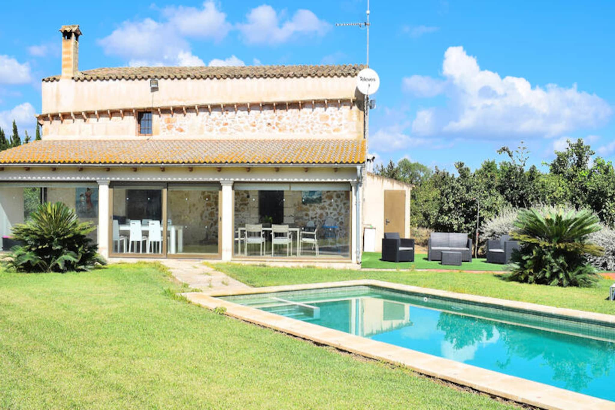 In the heart of Mallorca’s serene countryside, this delightful villa in Muro invites you to experience the perfect blend of comfort and Mediterranean charm. Just a short 5-minute drive from the pristine beaches of Can Picafort, this property offers a tranquil retreat surrounded by lush orange groves and idyllic landscapes. Wake up to the gentle sounds of nature and enjoy the warmth of the island sun in your own private oasis. Whether you’re seeking relaxation or adventure, this villa is the ideal base for your Mallorcan getaway. \n\nThe villa comfortably accommodates up to six guests across two floors. On the ground floor, you’ll find a welcoming living room with two plush sofas and satellite TV, a fully equipped kitchen that opens onto an air-conditioned porch, and a bathroom with a shower. Upstairs, three charming bedrooms await—one with a double bed and two with twin beds—alongside a bathroom with a bathtub. The porch features two dining areas, perfect for enjoying meals al fresco while soaking in the peaceful ambiance. Modern amenities such as Wi-Fi and air conditioning throughout ensure a comfortable stay. \n\nStep outside to discover a beautifully landscaped garden surrounded by orange trees, a refreshing 3x5 meter swimming pool, sun loungers, and a barbecue area. A ping-pong table adds a playful touch, making it an ideal spot for family gatherings or evenings with friends. The villa’s outdoor spaces are designed to create unforgettable moments under the Mediterranean sky. \n\nLocated between Muro and Can Picafort, this villa offers easy access to the island’s treasures. Explore the charming cobblestone streets of Muro, indulge in local cuisine, or venture to nearby beaches for sun-soaked days by the sea. With its authentic Mallorcan character and proximity to key attractions, this villa promises a holiday filled with relaxation, discovery, and lasting memories.