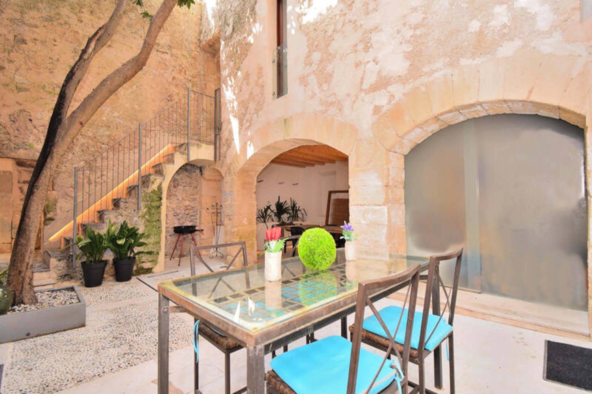 In the heart of the enchanting village of Artá, Mallorca, this charming house invites you to experience the perfect blend of tradition and modernity. Surrounded by cobbled streets and medieval architecture, this property offers a serene retreat for families and friends seeking an authentic island getaway. Imagine waking up to the gentle sounds of village life, stepping onto the rooftop terrace to take in breathtaking views of Artá, and enjoying the warm Mediterranean sun in the privacy of your own courtyard. This house is more than a place to stay; it’s a gateway to the magic of Mallorca. \n\nSpanning 250 m² across multiple floors, the house comfortably accommodates up to 12 guests. On the ground floor, a spacious living and dining area welcomes you, complete with a fireplace for cozy evenings. The fully equipped kitchen is perfect for preparing meals, while the ground-floor bedroom with a double bed and en-suite bathroom ensures convenience. Upstairs, three beautifully appointed bedrooms—two with twin beds and one with a double bed—all feature en-suite bathrooms. The top floor offers two additional bedrooms, each with twin beds and private bathrooms, making it ideal for larger groups. Fully air-conditioned and designed for comfort, this home ensures a relaxing stay year-round. \n\nStep outside to discover the charming courtyard, a tranquil spot to unwind with a book or a refreshing drink. The spa area provides a cool escape on hot days, while the rooftop terrace offers panoramic views of Artá’s historic beauty. Whether exploring the village’s vibrant culture or relaxing in the house’s inviting spaces, every moment here feels special. \n\nArtá’s location is unbeatable, with idyllic beaches and natural wonders just a short drive away. Stroll through the village’s cobbled streets, visit its medieval landmarks, and immerse yourself in Mallorcan traditions. For those seeking adventure, the surrounding landscapes offer hiking trails, cycling routes, and picturesque vistas. This house is your gateway to the authentic charm and beauty of Mallorca, promising unforgettable memories for every guest.