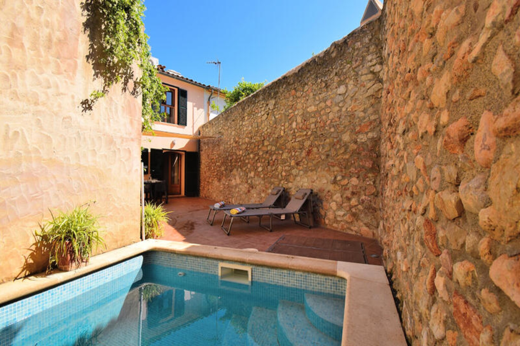 In the heart of the picturesque village of Binissalem, this charming apartment offers a tranquil retreat infused with the essence of Mallorcan life. Known for its rich wine heritage and traditional architecture, Binissalem invites you to explore its cobbled streets, local cellars, and vibrant culture. Whether you're here to savor the renowned wines or simply unwind in a serene setting, this property provides the perfect base for your island adventure.
Spanning 120 m², the apartment is thoughtfully designed to accommodate up to five guests. The ground floor features a private courtyard with a sparkling swimming pool, ideal for relaxing under the Mediterranean sun. The first floor boasts three cozy bedrooms and two full bathrooms, ensuring comfort for families or small groups. A spacious living and dining area with a fireplace creates a welcoming ambiance, while the fully equipped kitchen, complete with modern appliances, caters to all your culinary needs. Additional amenities include Wi-Fi, air conditioning, heating, and two smart TVs, ensuring a comfortable and connected stay.
Step outside and discover the beauty of Binissalem. From the local restaurants and markets to the nearby bus and train stations, everything is within walking distance. For those seeking adventure, the sandy beaches of Puerto Alcudia, the natural park of S'Albufera Muro, and the water park Aqualand Arenal are just a short drive away. Golf enthusiasts will appreciate the proximity to Golf Puntiró, while nature lovers can explore the stunning landscapes of Mallorca.
Whether you're a wine connoisseur, a family seeking a peaceful getaway, or a traveler eager to experience authentic Mallorcan culture, this apartment in Binissalem promises an unforgettable stay. Let the charm of this village and the comfort of this home create lasting memories.