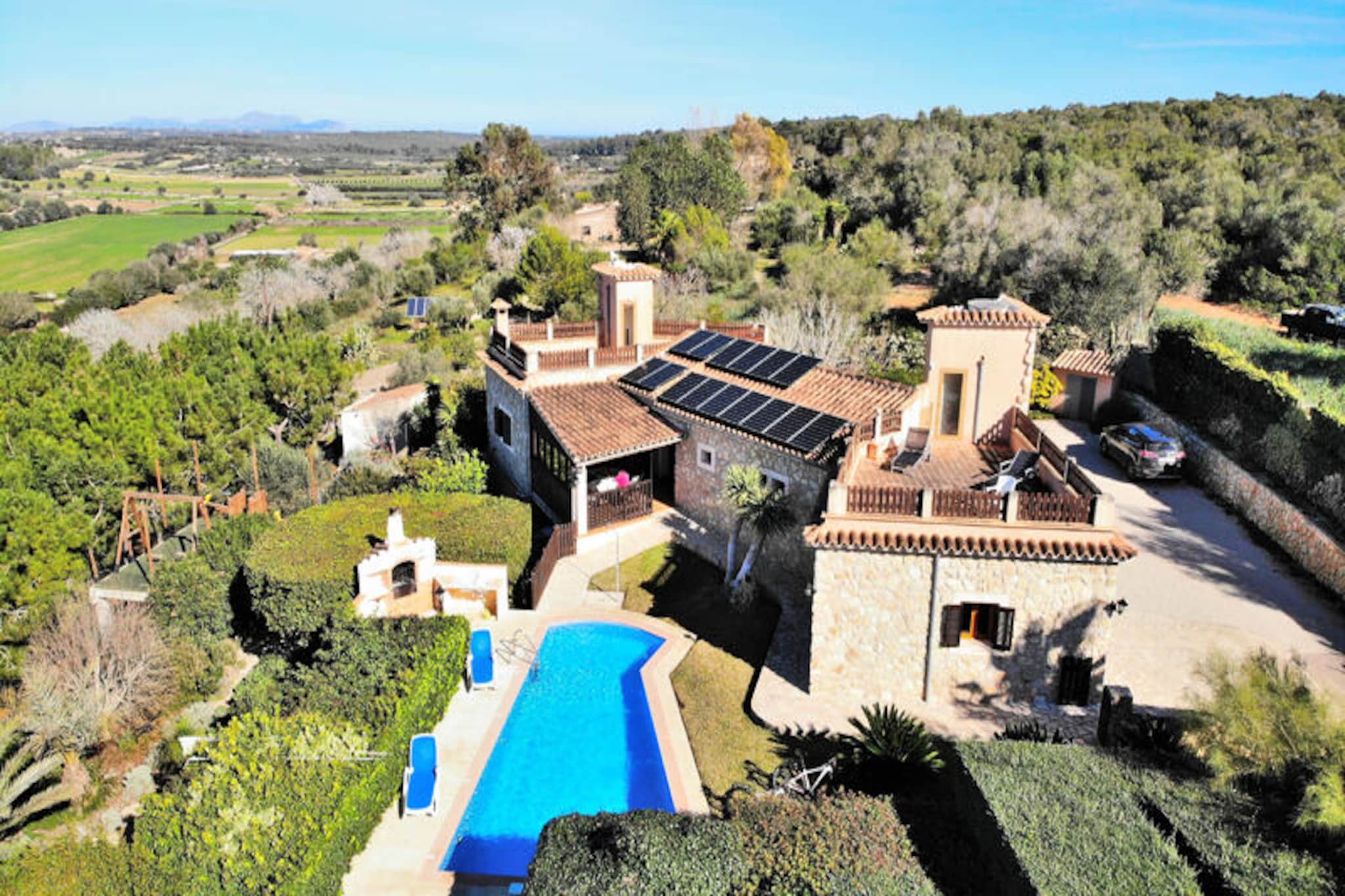 Amidst the serene countryside of Mallorca, this stunning stone villa offers an idyllic escape just 3 kilometers from the charming village of Ariany. Surrounded by golden fields and tranquil landscapes, the property invites you to experience the authentic beauty of the island away from the bustling tourist spots. Here, the gentle breeze carries the scent of Mediterranean flora, creating a peaceful haven for relaxation and exploration. \n\nSpanning 230 square meters, the villa is thoughtfully designed to combine modern comfort with traditional charm. It features three beautifully appointed bedrooms, accommodating up to six guests with two double beds and two singles. Two full bathrooms, one with a bathtub and the other with a shower, ensure convenience, while the fully equipped kitchen and cozy living/dining area provide all the essentials for a comfortable stay. Satellite TV, high-speed internet, and air conditioning in the bedrooms cater to your modern needs, while the fireplace adds a touch of warmth during cooler evenings. Sustainability is at the heart of this retreat, powered entirely by solar panels. \n\nStep outside to discover a private oasis complete with an 8x4 meter swimming pool surrounded by sun loungers, a spacious barbecue area, and a play zone with a slide and swing for younger guests. Bicycles are available for exploring the scenic surroundings, and the expansive garden is perfect for stargazing or enjoying Mallorca’s mild evenings. Whether you’re seeking active adventures or quiet moments, this property delivers an unforgettable experience. \n\nLocated near Ariany, a picturesque village known for its serene streets and local charm, the villa offers easy access to historical sites and day-trip destinations across Mallorca. With its blend of rural authenticity and modern amenities, this retreat is the perfect choice for families, couples, or friends looking to immerse themselves in the tranquil beauty of the island.