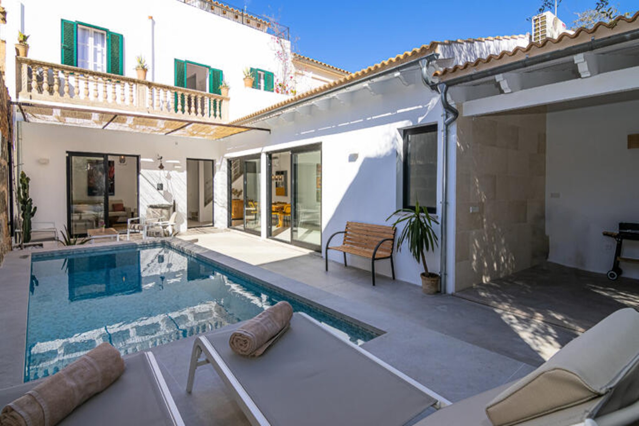 In the heart of Muro, a picturesque village in Mallorca, this stunning three-story house invites you to experience the perfect blend of Mediterranean charm and modern comfort. Just 10 km from the pristine Muro beach, often hailed as one of Europe’s finest, this home is a haven for those seeking tranquility and luxury. Surrounded by the authentic beauty of cobblestone streets and traditional Mallorcan architecture, the property offers a unique retreat for families or groups of friends. From its spacious interiors to its sunlit garden, every corner of this house is designed to inspire relaxation and joy.
Step inside to discover a thoughtfully designed space featuring four bedrooms, each tastefully decorated to ensure maximum comfort. The ground floor boasts a cozy living room, a fully equipped kitchen, and a bedroom with an en-suite bathroom for added privacy. Upstairs, three additional bedrooms await, including one with its own en-suite, while the others share a stylish bathroom. The top floor offers a versatile games room equipped with a ping-pong table, PlayStation, and a dedicated workspace with wired internet access, making it ideal for both leisure and work.
The outdoor area is a true highlight, featuring a refreshing swimming pool and a barbecue area where you can bask in the Mediterranean sun. The spacious solarium on the third floor provides panoramic views of the surrounding village and the majestic Sierra de Tramuntana, creating the perfect backdrop for unforgettable moments.
With its proximity to Muro beach, local markets, and exquisite dining options, this property is your gateway to discovering the essence of Mallorca. Whether you’re exploring the idyllic countryside or relaxing by the pool, this home promises a memorable stay filled with comfort and authenticity.