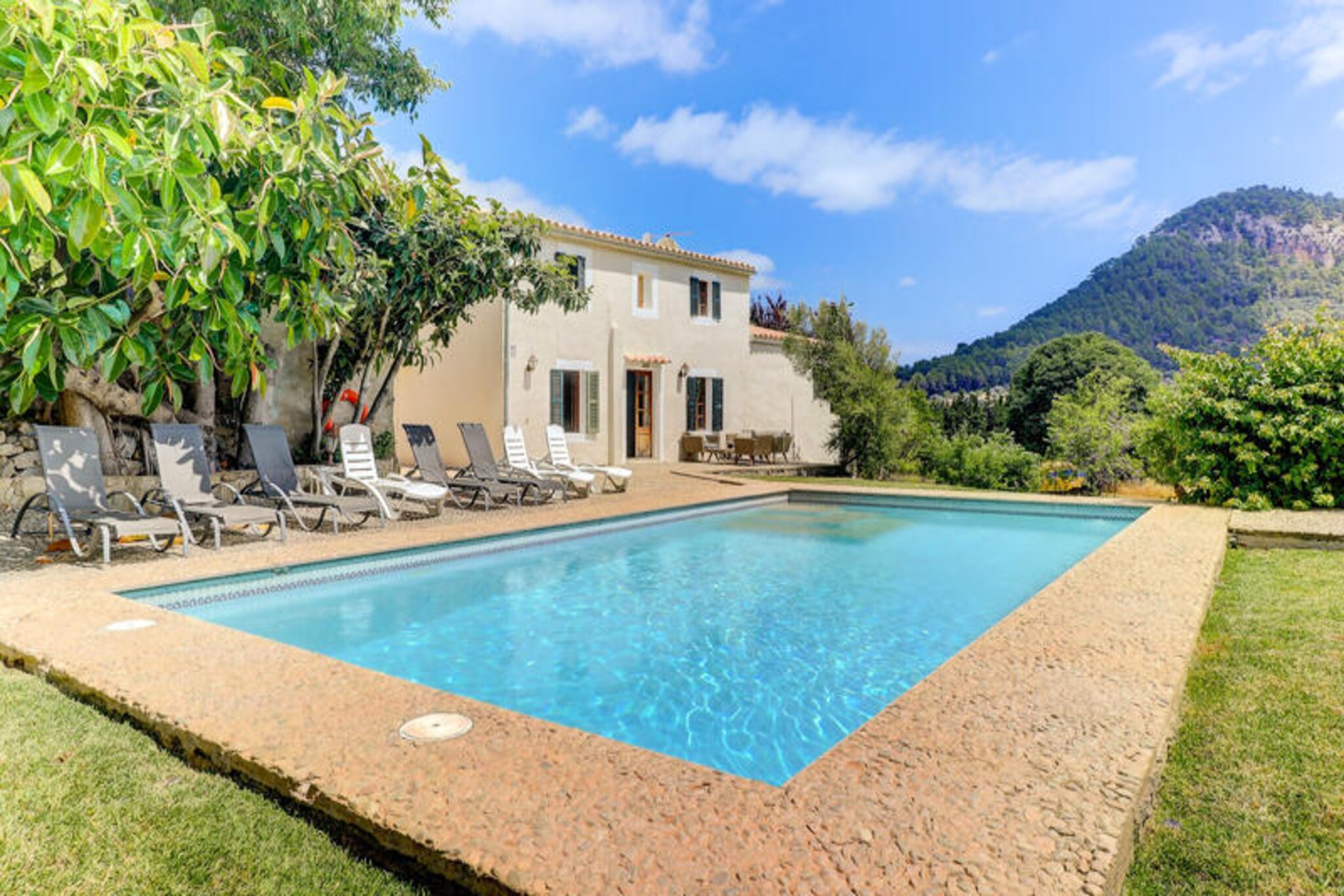 In the serene Valle de Colonya near Pollença, this stunning villa invites you to experience the perfect blend of Mallorcan charm and modern luxury. Surrounded by lush greenery and breathtaking mountain views, this property offers an idyllic retreat for those seeking tranquility and exclusivity. Whether you're basking in the Mediterranean sun or enjoying the peaceful ambiance of the gardens, every moment here feels like a slice of paradise. \n\nDesigned to accommodate up to 14 guests, the villa boasts seven spacious bedrooms and five bathrooms, making it ideal for large families or groups of friends. The ground floor features a double bedroom with an en-suite bathroom, two single bedrooms, a shared bathroom with a shower, and a bright living room with terrace access. The fully equipped kitchen and dining area are perfect for preparing and sharing meals together. Upstairs, you'll find the master bedroom with an en-suite bathroom, two double bedrooms, one twin bedroom, and a family bathroom with both a shower and bathtub. A separate annex provides additional privacy with a double bedroom and en-suite bathroom. \n\nThe outdoor spaces are a true highlight, offering a private swimming pool surrounded by sun loungers, a covered barbecue area with outdoor dining, and multiple terraces for relaxation. The expansive gardens provide a perfect setting for family activities or quiet moments immersed in nature. \n\nLocated just five minutes from Pollença’s historic center, you’ll have easy access to its charming weekly market, cafes, and traditional restaurants. The beaches of Puerto Pollença and Cala San Vicente are only 10-15 minutes away, offering pristine waters and exciting water sports. Golf enthusiasts will appreciate the nearby Pollença golf course. For a holiday filled with privacy, comfort, and unforgettable Mediterranean beauty, this villa is your ultimate destination.