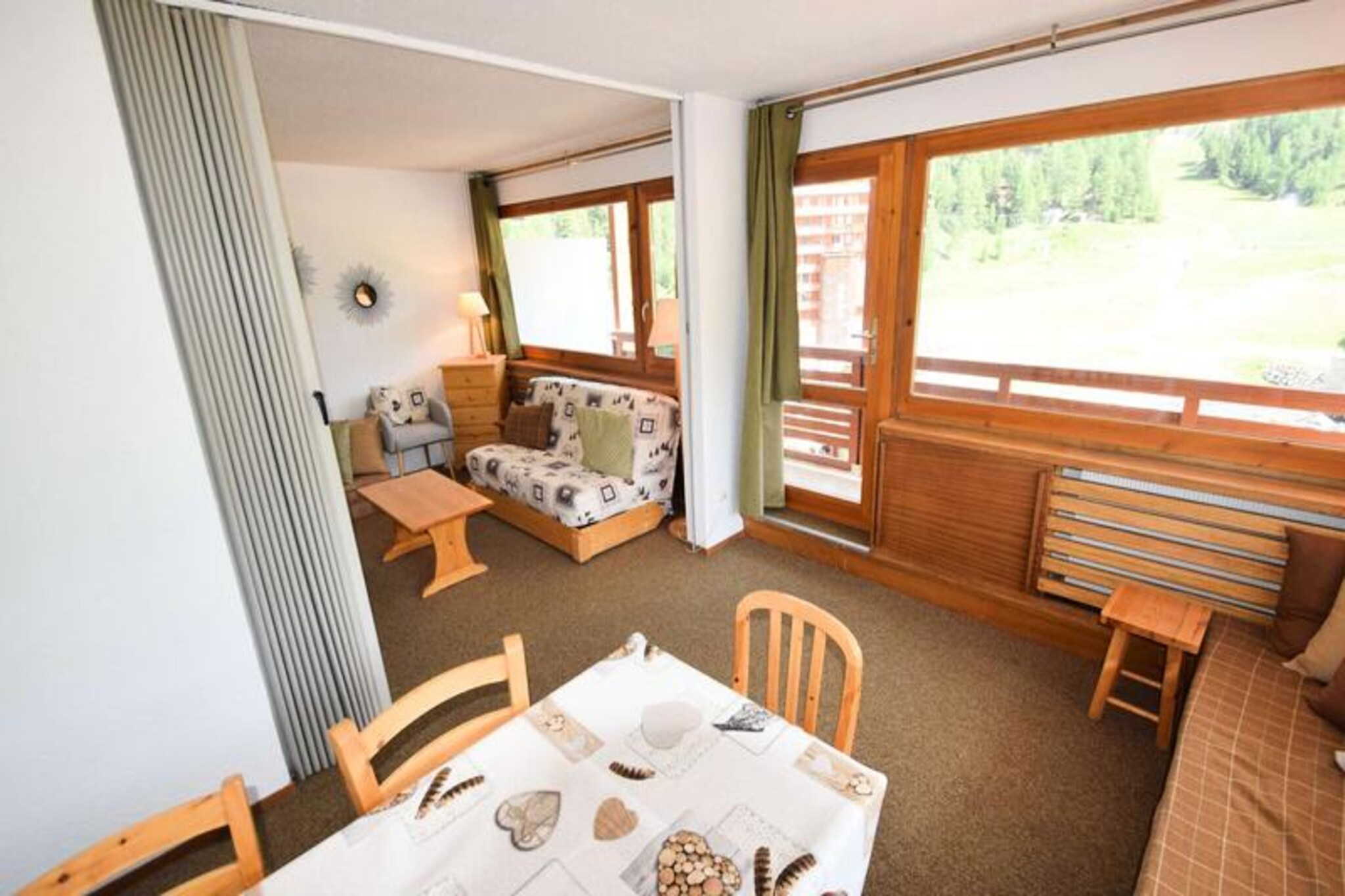 High above the bustling heart of Plagne Centre, this charming apartment offers a front-row seat to the alpine slopes, with breathtaking views from its southwest-facing balcony. Imagine waking up to the crisp mountain air and the sight of skiers carving their way down the pristine runs, all from the comfort of your own private retreat. Positioned on the 9th floor (accessible via elevator), this residence combines convenience with the serenity of elevated living, making it the perfect base for your next adventure in the French Alps. \n\nInside, the apartment is thoughtfully designed to accommodate up to six guests, offering a cozy yet functional layout. The living room features a comfortable double sofa bed and a TV, while the divisible dining area includes an additional single sofa bed. The bedroom is equipped with two single bunk beds and a single bed, ensuring flexible sleeping arrangements for families or groups. A fully equipped kitchen with ceramic hobs, an oven, refrigerator, and dishwasher makes meal preparation a breeze, while the bathroom with a bathtub and separate WC adds to the comfort. The combination of carpeted and tiled flooring creates a warm and inviting atmosphere, perfect for unwinding after a day on the slopes. \n\nSituated at the foot of the slopes, the residence offers direct access to the ski lifts and a convenient shopping arcade, putting everything you need right at your fingertips. Whether you’re picking up ski passes, grabbing a quick bite, or exploring the vibrant resort atmosphere, you’ll find it all just steps away. The ski locker ensures hassle-free storage, making your transition from apartment to piste seamless. \n\nThis apartment is more than just a place to stay; it’s a gateway to unforgettable alpine experiences. Whether you’re here to ski, hike, or simply soak in the stunning views, La Meije in Plagne Centre promises a holiday filled with comfort, adventure, and memories to last a lifetime.