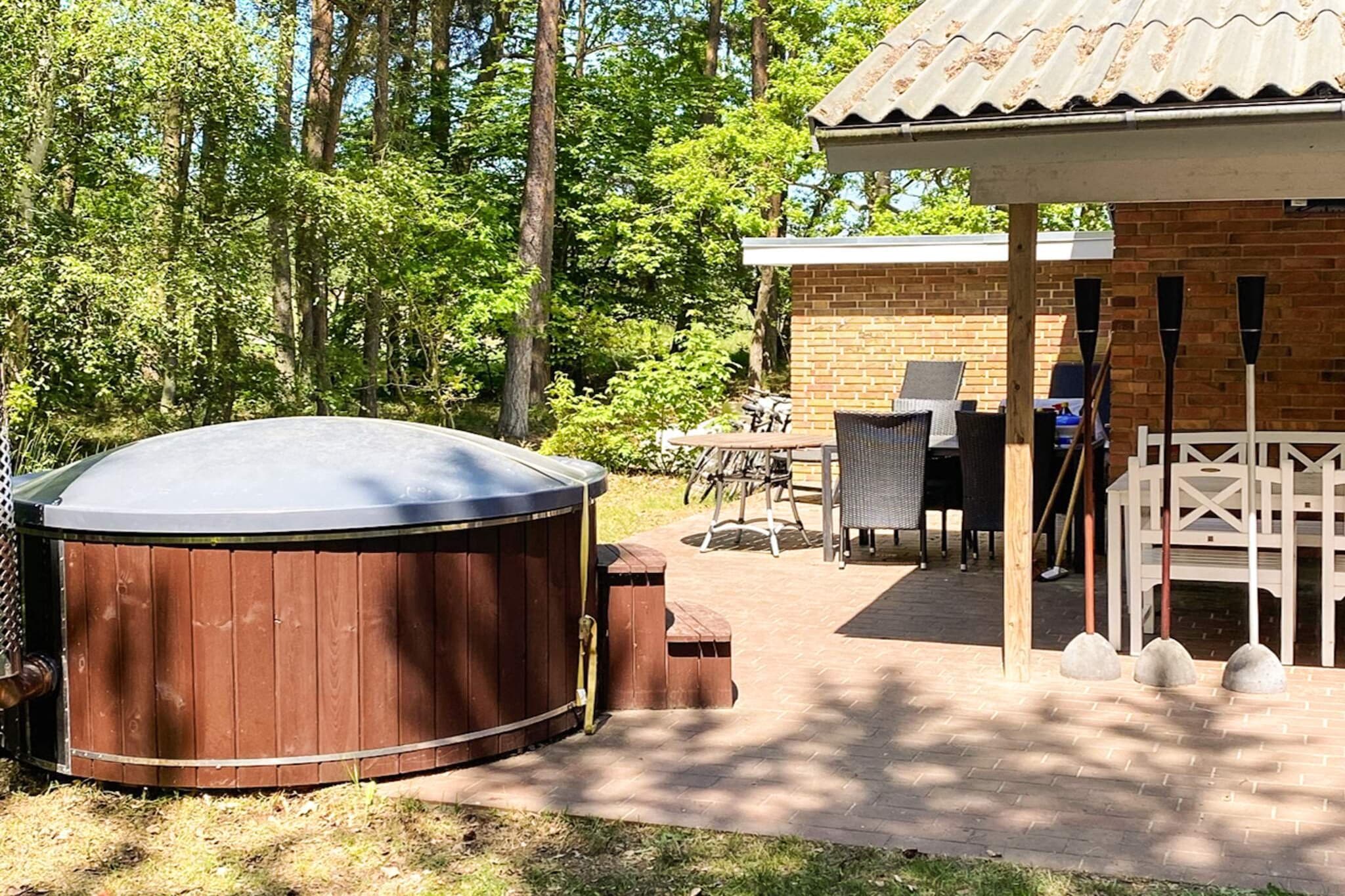 This newly listed, spacious holiday home, spanning 95 square meters and including a separate annex, is perfectly set on a large 2626 m² natural plot. Designed to accommodate up to 8 guests, the property blends rustic charm with modern amenities, making it ideal for families seeking relaxation and outdoor enjoyment. The main cottage features a comfortable living room equipped with a cosy wood-burning stove, TV, DVD player, Chromecast, and Bluetooth connectivity. The fully-equipped kitchen makes meal preparation easy with an electric hob, oven, fridge-freezer, microwave, coffee maker, and a washing machine. The house offers three bedrooms, all furnished with a double bed plus a separate annex which contains an additional double bed , bringing the total to four sleeping areas. A modern bathroom with a shower is also included. Outdoor life is a highlight, with a large terrace furnished with garden furniture, deck chairs, and a gas grill. A standout feature is the outdoor hot tub (Wilderness Bath), which seats 4 people and is heated, providing a unique spot for relaxation under the stars. Guests can enjoy the large grounds, which include playground equipment for children and an outdoor shower. The location is conveniently close to amenities: a restaurant at 1.2 km, a grocery store at 2.3 km, and a golf course at 3.0 km. For climate control, the house is equipped with electric heating and an an air-to-air heat pump.A refundable deposit might be charged closer to your check-in date. The security deposit ensures a smooth stay and covers any additional services or consumption charges.This deposit covers utilities consumed during your stay and any additional services that may be taken.The final amount will be adjusted based on actual meter readings, actual usage of extra services, and any remaining balance will be refunded within 21 days after checkout.This deposit simply acts as a prepayment for charges that you would anyways pay for, ensuring a seamless stay and check-out experience.