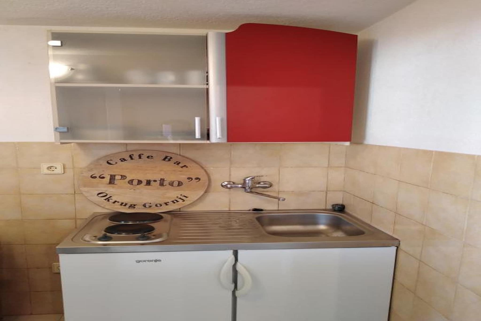 Designed for couples or solo travellers seeking a peaceful coastal escape, this charming ground-floor apartment in Okrug Gornji offers a cosy and welcoming retreat just moments from the Adriatic Sea. The living–bedroom space is thoughtfully arranged with a comfortable double bed (or two single beds), a snug seating area by the fireplace, a TV and a dining table creating the perfect atmosphere for quiet mornings, relaxed evenings or a restful night after exploring the island. A radio adds a nostalgic touch, inviting you to unwind with soft music.

The open kitchen is equipped with everything you need for simple, home-cooked meals, including a coffee machine, electric kettle, fridge-freezer, dishes, cutlery and cooking basics. The bathroom features a bathtub with a shower, offering you the choice between a refreshing rinse or a long, soothing soak. With internet access available, staying connected is easy whenever you need it.

Step outside onto your private terrace to enjoy breakfast in the fresh air, a quiet drink at sunset or an afternoon spent reading in the shade. Guests can also use the shared swimming pool perfect for cooling off during warm summer days—and a grill area for outdoor dining. Private parking adds convenience throughout your stay.

Located on the island of Čiovo, Okrug Gornji is known for its clear turquoise waters, pebble beaches and relaxed Mediterranean atmosphere. Beach bars, small markets and seaside restaurants are just minutes away, and the UNESCO-listed town of Trogir is a short drive from the apartment. Whether you’re exploring hidden bays, taking a boat trip or simply enjoying the calm surroundings, this apartment offers a comfortable and heartfelt base for your holiday on the Dalmatian coast.
