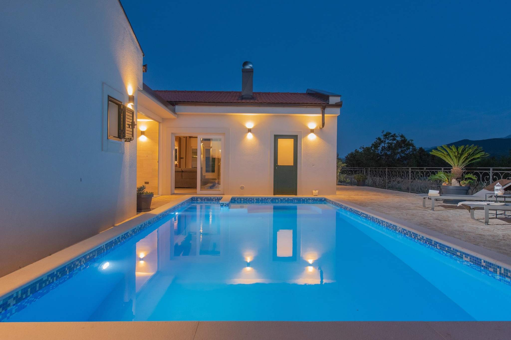 Set in the peaceful village of Lovreč, tucked into the green hills above the coast, Villa Unika is made for friends who want to slow everything down. This 200 m² private retreat for up to 10 guests, set on a vast 2,000 m² fenced estate, trades nightlife for stillness, schedules for shared routines, and noise for open space.

Inside, the villa is generous yet calming. Four spacious en-suite bedrooms, each with a double bed and a walk-in shower, give everyone proper privacy without losing the feeling of being together. The central living room, with its fireplace, convertible sofa seating, a dining table and TV, becomes the natural gathering point for slow breakfasts, mid-day chats, and unplanned game nights. The fully equipped kitchen - built for long cooking sessions and relaxed group meals.

Outside, life moves at water temperature. The heated pool, sauna and wide sun deck with loungers stretch the day effortlessly. The covered outdoor kitchen and terrace are where afternoons drift into dinner with almost no transition. There’s space for gentle activity too - shaded lounging corners, and even a small organic garden for picking fresh produce.

Daily essentials sit just a short walk from the villa, while soft day trips stretch toward the Cetina River or the viewpoints of Biokovo. When a full city mood is needed, Split is within a few minutes’ drive.

Villa Unika is best suited for friends who want space, spa-level comfort, privacy without isolation, and a house that supports slow living rather than pushing movement. Here, the days arrive gently, and the nights end without urgency.