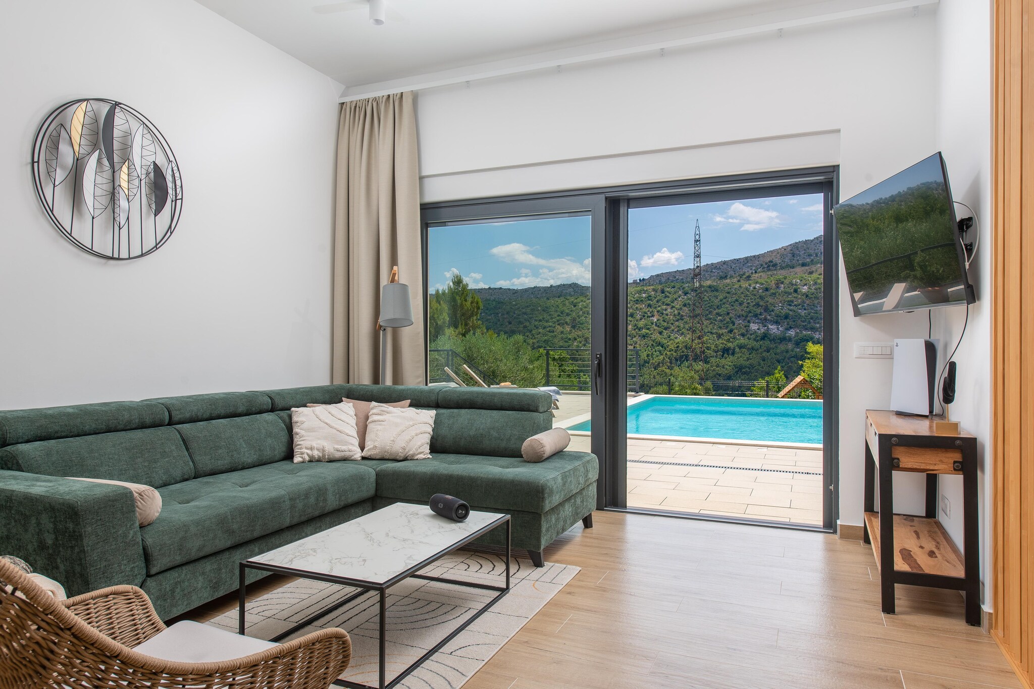 In the serene village of Naklice, just inland from the coast near Omiš, you’ll find this amazing Villa Nacle - designed for families who want space, privacy, and easy access to both nature and the sea. Spread across 160 m² on a 1,000 m² private plot, this fully air-conditioned villa for six guests makes daily life feel unhurried and comfortable.
Inside, the home centres around a bright open-plan living area where the lounge, dining space, and fully equipped kitchen flow together naturally. Parents can relax while kids watch TV, play games on the PS, or gather around the table for shared meals, and a bathroom for added comfort. Upstairs, you’ll find three well-appointed bedrooms, each with a TV, giving everyone their own quiet space at the end of the day with a shared bathroom. High-speed Wi-Fi, washer and dryer, and thoughtful storage support longer family stays with ease.
Outside becomes the real family playground. The private heated pool sits within clear view of the covered seating area. A trampoline, shaded lounge corner, sun deck, and outdoor dining area create flexible zones for play, rest, and meals. The barbecue turns meals into an outdoor picnic, while children wind down nearby.
Daily outings stay easy. Beaches, shops, and the historic heart of Omiš are only a short drive away. Active families can explore the Cetina River for rafting and zip-lining, while cultural day trips to Split add variety. A highlight family excursion includes a boat trip to Zlatni Rat on Brač.
Villa Nacle is best suited for families who want a safe home base with a private heated pool, play space for kids, and quick access to beaches, nature, and Dalmatia’s most family-friendly adventures - without the pressure of resort crowds.