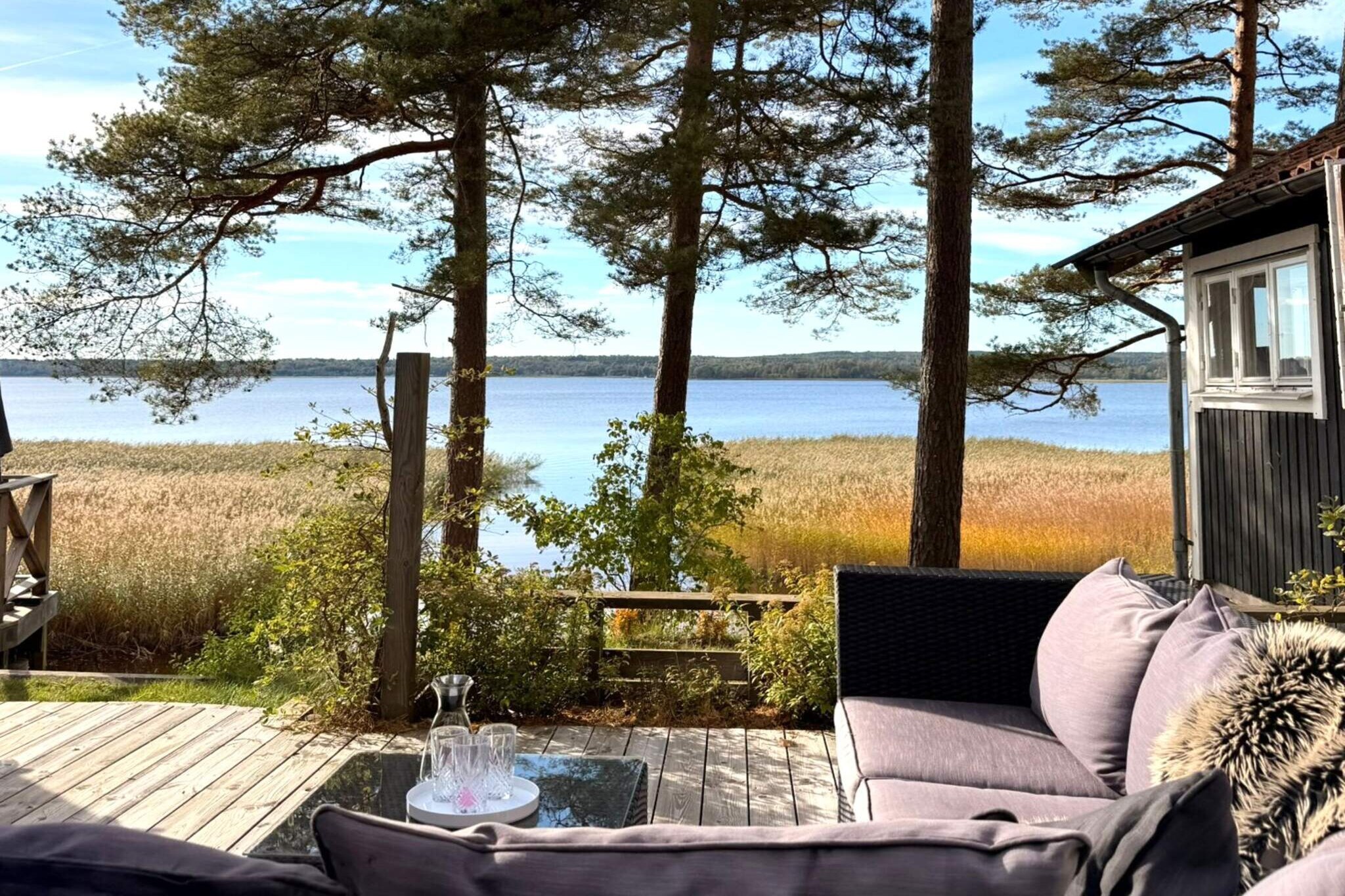 Welcome to a nature-close retreat by the sparkling waters of Lake Vidöstern. This charming home offers comfortable accommodation in all seasons and is located just a few meters from the lake’s shoreline. Here, you can enjoy expansive lake views, a private jetty, and the peaceful silence of the surrounding forest – perfect for both relaxation and adventure. This bright, recently renovated home accommodates up to eight guests, featuring an open-plan design with large windows for natural light and beautiful views of the surrounding landscape. The living room offers comfortable seating and a wood fireplace for year-round warmth and atmosphere, while the fully equipped kitchen and dining area provide an ideal setting for family meals with panoramic lake views. The house includes three bedrooms and a cozy sleeping loft with two floor mattresses, along with a modern bathroom and toilet. Outside, the spacious lake-facing terrace features outdoor seating, barbecue facilities, and room for long summer evenings, both open-air and enclosed. A private jetty invites morning swims, fishing, or boating, while the large garden offers plenty of space for play and quiet relaxation. Lake Vidöstern offers excellent swimming opportunities as well as rowing and fishing for those who wish. The surrounding area also features hiking trails, cycling routes, and family-friendly excursion destinations. The summer-open Wild West theme park “High Chaparral” is a popular attraction for visitors of all ages. Other highly recommended nearby destinations include Vandalorum Museum of Art & Design, Store Mosse National Park, and Åminne Bruk.