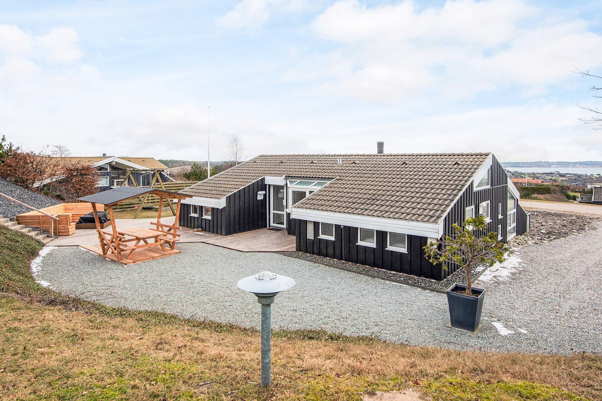 Well-located holiday home with indoor pool, sauna and panoramic views at Handrup Bakker This spacious and well-maintained holiday home is located in the attractive area of Handrup Bakker, close to Ebeltoft. The house accommodates up to 8 people and is ideal for both family holidays and stays with friends. The holiday home is bright and modern, featuring an open-plan living room and kitchen. From the living room, you can enjoy beautiful panoramic views over the bay, the coastline, and the town of Ebeltoft, and in clear weather, Samsø can be seen on the horizon. The house is equipped with energy-efficient solutions, including a heat pump and air conditioning, ensuring a comfortable indoor climate all year round. An air-to-water heat pump is used to heat the pool, providing the lowest possible cost for pool heating. There are 4 bedrooms and 2 bathrooms with underfloor heating. The house’s indoor swimming pool and sauna offer relaxation in every season. Outside, there is a landscaped 1,270 m² plot with lovely terraces facing both north and south, garden furniture, sun loungers, and a barbecue. There is plenty of space for both relaxation and play, and the property also features a cozy fire pit, perfect for making twist bread and enjoying time together on warm summer evenings. For the youngest members of the family, there is an activity room with space for play and relaxation – and at the same time, a wonderful view, so both children and adults can enjoy the surroundings. Free parking is available on the property, and one dog is allowed. The area offers great bathing beaches, scenic hiking and cycling routes, as well as nearby restaurants. Ebeltoft is about 6 km from the house and offers charming streets, shopping, and attractions. The holiday home is also an excellent base for excursions around Djursland and the rest of East Jutland. A well-equipped holiday home in beautiful natural surroundings, focused on comfort, views, and relaxation.A refundable deposit might be charged closer to your check-in date. The security deposit ensures a smooth stay and covers any additional services or consumption charges.This deposit covers utilities consumed during your stay and any additional services that may be taken.The final amount will be adjusted based on actual meter readings, actual usage of extra services, and any remaining balance will be refunded within 21 days after checkout.This deposit simply acts as a prepayment for charges that  you would anyways pay for, ensuring a seamless stay and check-out experience.