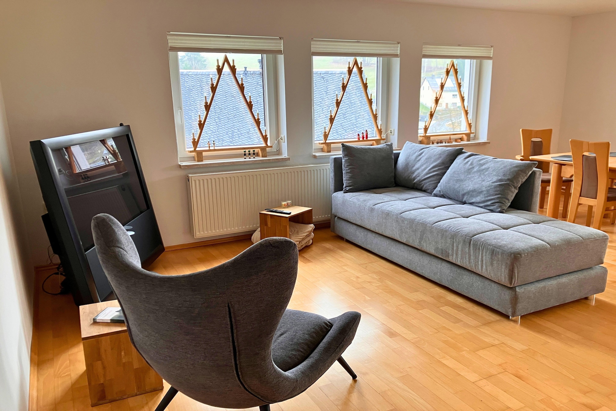 The holiday apartment on the upper floor is ideal for families. The apartment is modern and furnished to a high standard. It is 80 m² and features two hallways, a living area, a combined living room and kitchen, a bedroom, and a bathroom. The upstairs hallway includes a workspace and a sleeping alcove. Both the living area and the bedroom have televisions. The fireplace in the living area is fueled by environmentally friendly pellets, which are available upon request. In summer, the furnished balcony is perfect for relaxing on long summer evenings. The fully equipped kitchen includes a breakfast bar and a dining table.

Sleeping arrangements are very flexible. The bedroom has two single beds and two pull-out beds for younger children. The sleeping alcove in the hallway is ideal for an older child. Alternatively, the sofa in the living room can be converted into a bed for two people. Plenty of flexible options for a family!

A parking space on the property is available free of charge. Please note that the interior of this holiday apartment is NOT wheelchair accessible. Baby equipment is available upon request. The playground in the garden may be used at your own risk. Parents are responsible for their children. Animals of any kind are unfortunately not allowed. Smoking is only permitted outdoors.