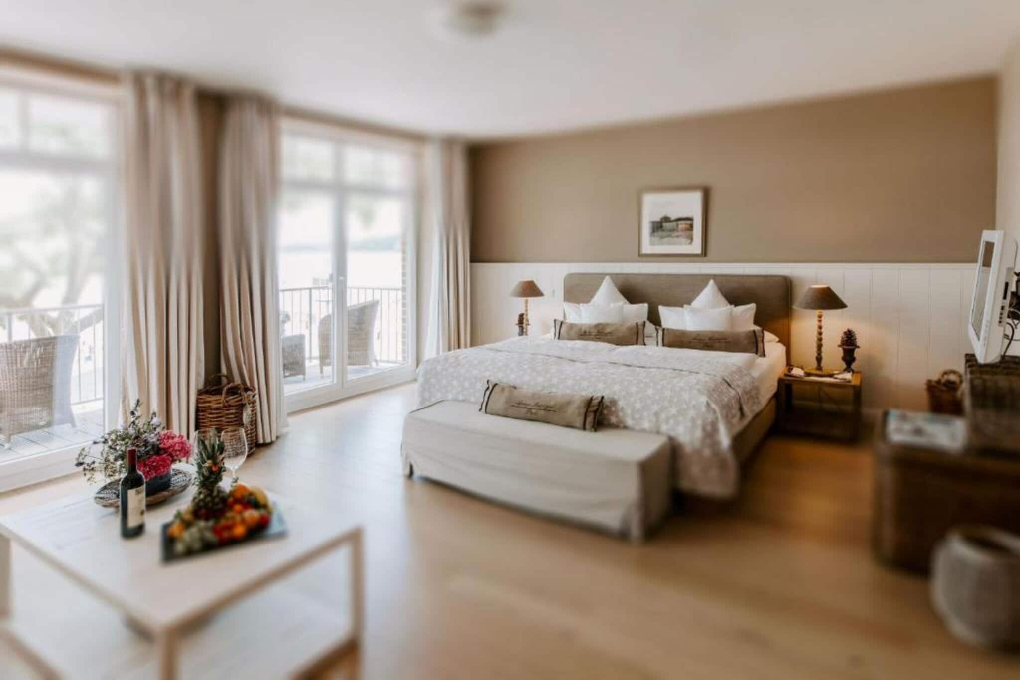 Located directly on the Baltic Sea coast in Heikendorf, this 47 m² Junior Suite Adults Only Sea Side offers elegant seaside living with panoramic sea and lake views. Ideal for couples seeking comfort and tranquillity, the suite combines generous space, refined interiors and direct access to the beach promenade. A spacious living area and private balcony create the perfect setting to relax while enjoying the coastal atmosphere of the Kiel Fjord.

 Room Amenities

1. 47 m² spacious junior suite with living area.
2. One extra-large double bed with high comfort rating.
3. Private balcony with sea and lake views.
4. Soundproofed interiors for peaceful rest.
5. Flat-screen TV with cable channels, radio and telephone.
6. Minibar and electric kettle.
7. Desk and comfortable seating area.
8. Private bathroom with bath, shower, bathrobes, slippers and hairdryer.
9. Complimentary toiletries and towels.
10. Free WiFi and safety deposit box.

Hotel Amenities & Services

1. Direct beachfront location.
2. Sauna and wellness facilities.
3. On-site restaurant and breakfast service.
4. Lift access and non-smoking rooms.
5. Free WiFi in public areas.
6. Soundproofed and allergy-friendly options.
7. Parking is available for 10 euro per night (payable on-site)

Nearby Attractions

1. Kiel city centre – approx. 10 km.
2. Naval Memorial Laboe – approx. 5 km.
3. Kiel Fjord promenade – walking distance.
4. Baltic Sea beaches – direct access.

How to Reach

1. Kiel Central Station – approx. 10 km.
2. Hamburg Airport – approx. 100 km.
3. Easy access by car with nearby parking facilities.

This Junior Suite Adults Only Sea Side offers the perfect blend of coastal elegance, comfort and Baltic Sea charm for a memorable seaside escape.