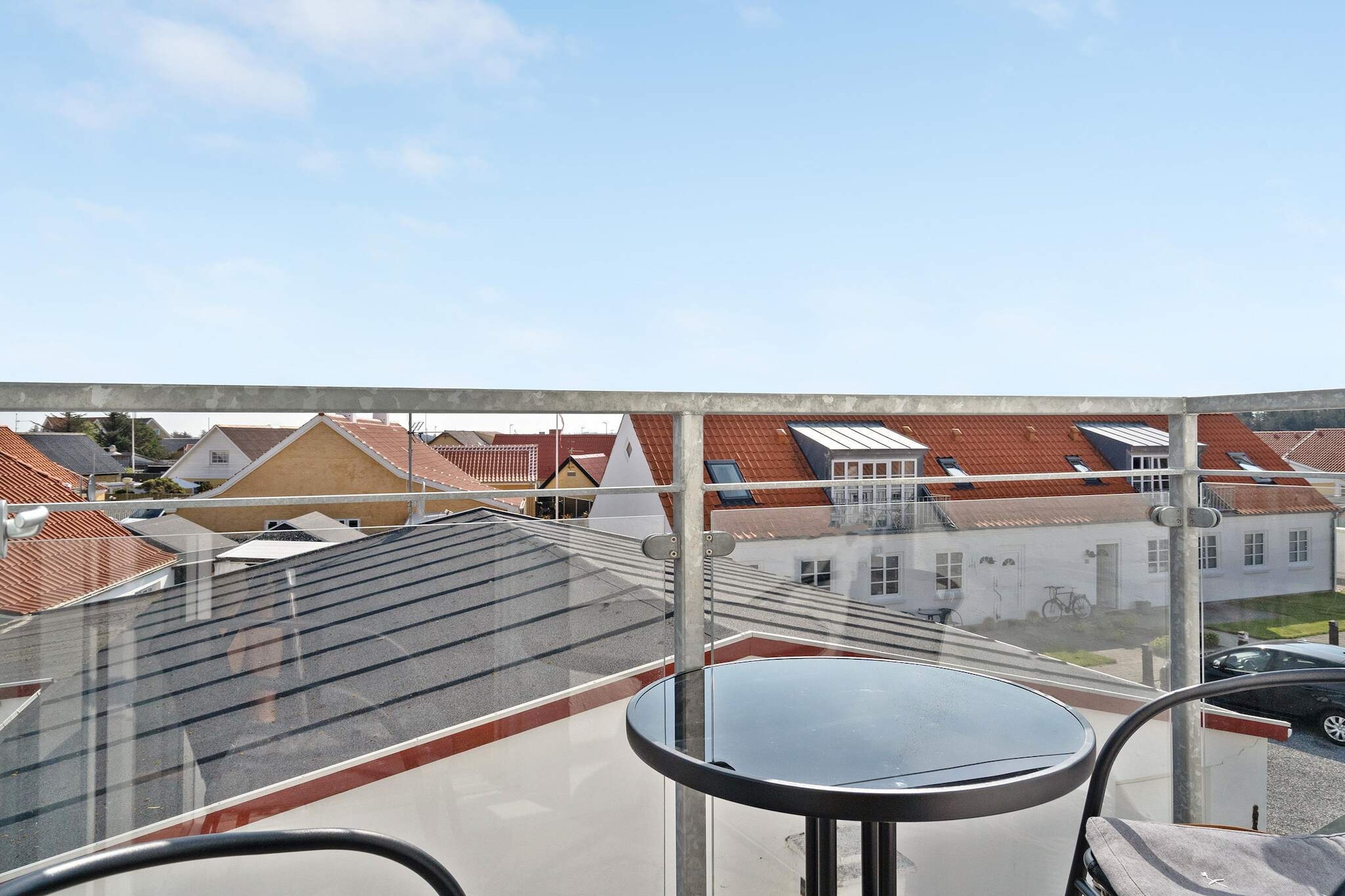 Experience a unique combination of historical charm and modern comfort in this 3\text( m)^2$ holiday apartment, located in the heart of Løkken city centre. The building, which previously housed a lively disco, has now been transformed into bright and airy accommodation with respect for the old warehouse's architecture. Inside, the characteristic curved windows and exposed beams in Norwegian hewn wood create a very special atmosphere, while the thick walls ensure an impressive calm, even though the city's vibrant life awaits just outside the door. The apartment is thoughtfully furnished with a combined living room and kitchen, from which there is access to a cozy, small balcony.

The sleeping accommodations are distributed over two regular bedrooms and a spacious loft with space for two people, making the home ideal for both families and friends. Practical details such as built-in cupboards in the hallway and a bright bathroom with shower ensure that functionality is at its best during the entire stay.

Here you get a base where light streams in and the neighbors are not noticeable, creating the perfect setting for a relaxing holiday. Please note that the holiday apartment is non-smoking and rentals to youth groups are not permitted in order to maintain the quiet environment of the property.