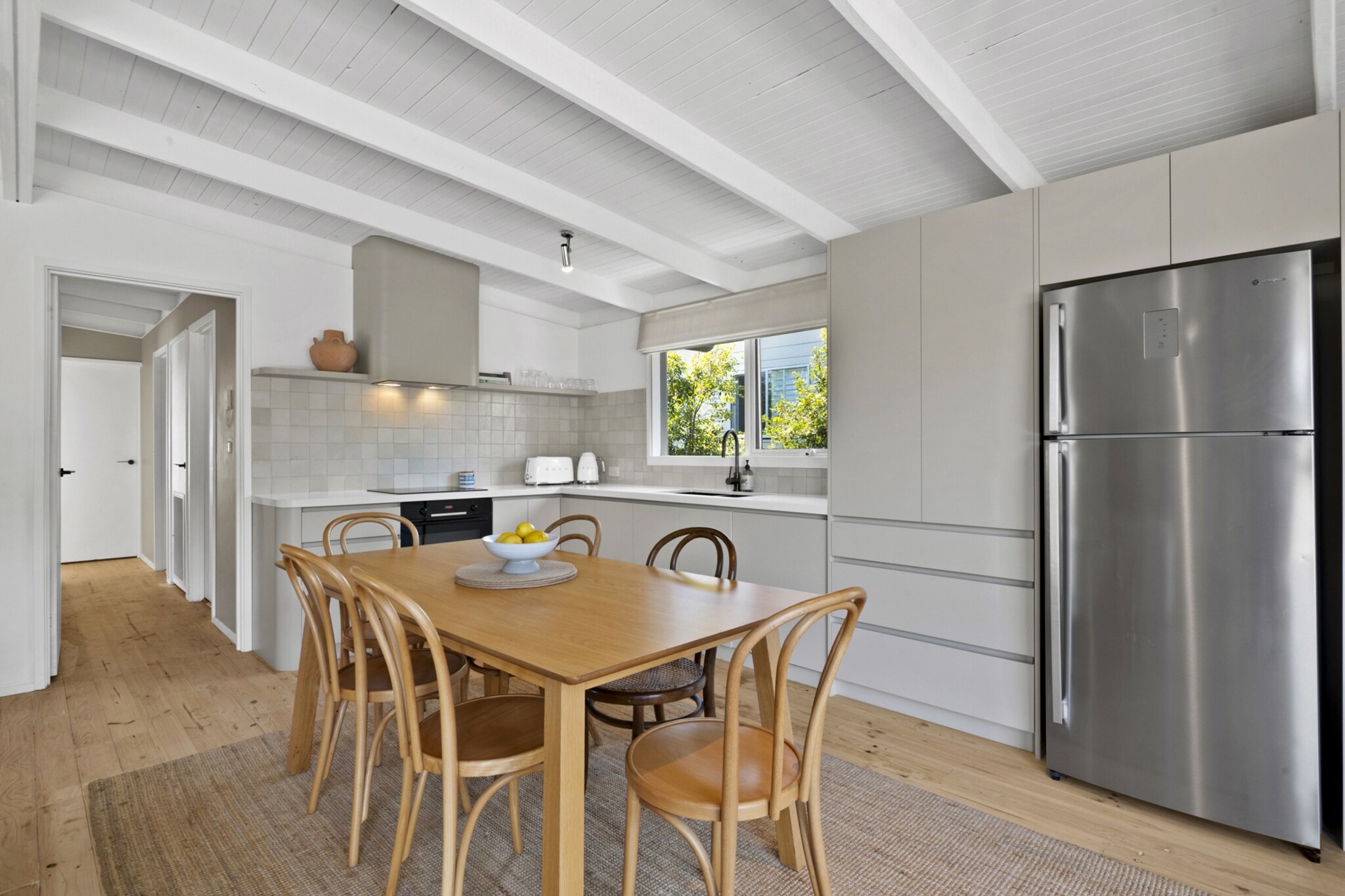 Property description
Set in a peaceful Rye location, this spacious coastal house offers relaxed living with generous indoor and outdoor areas. Enjoy comfortable furnishings, a fireplace for cooler evenings, and a private deck with BBQ for alfresco dining. With convenient onsite key access and parking, it’s an ideal base for beach holidays and Peninsula escapes.
The space
Step inside to a bright and welcoming living area styled with comfortable furnishings and warm timber flooring underfoot. A generous six-seater sofa invites you to unwind in front of the TV, while the nearby dining area with seating for six creates an easy flow for shared meals and conversation.
 
The kitchen is well-equipped for home cooking, featuring an electric stovetop, gas oven, dishwasher, coffee machine and ample preparation space. Whether preparing a quick breakfast or a relaxed dinner, everything is within reach.
 
Three well-appointed bedrooms provide a restful retreat, including two queen beds and two single beds, each fitted with blackout blinds for a peaceful night’s sleep. Bedside tables and lamps add both comfort and convenience. The bathroom is practical and neatly presented, complete with essential amenities.
 
Outdoors, the property opens to a private deck on the right-hand side, complete with full outdoor furniture and a gas BBQ. Surrounded by natural coastal landscaping, the garden space offers a tranquil setting to enjoy fresh air and relaxed Peninsula evenings.