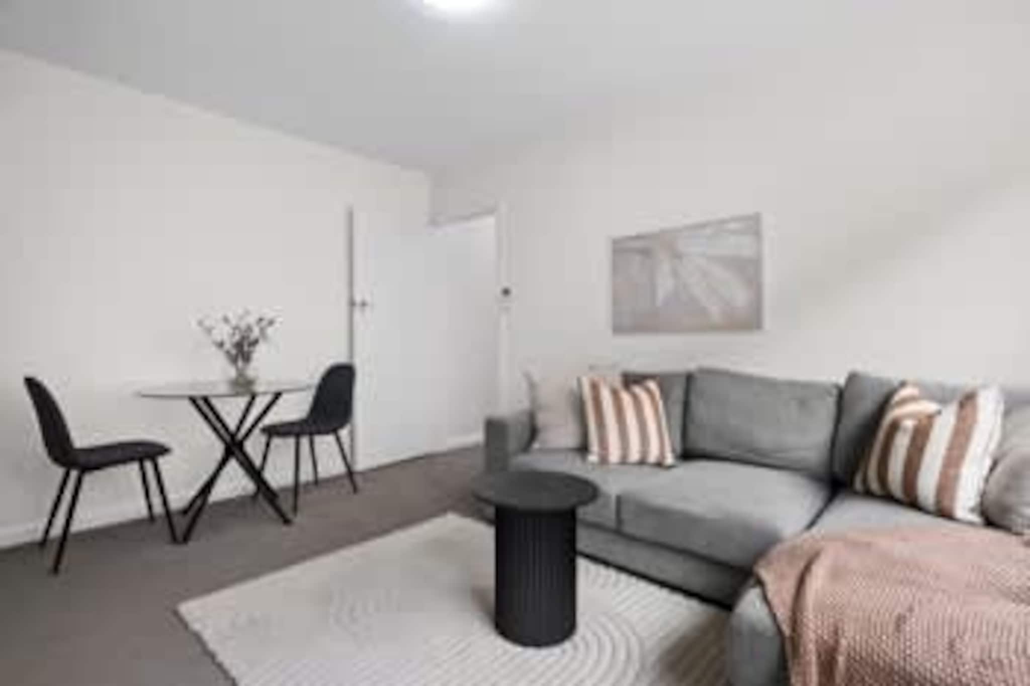 Property description
Set in lively St Kilda, this well-presented 1-bedroom apartment offers a comfortable base close to the beach, cafés, and public transport. Featuring a separate lounge area, functional kitchen, and private laundry, the apartment suits couples or solo travellers. With convenient offsite key collection, it provides an easy and flexible stay in one of Melbourne’s most popular coastal suburbs.
The space
This welcoming apartment offers a practical and comfortable layout, ideal for short stays in Melbourne’s bayside. The living area is neatly arranged with a sofa, rug, and coffee table, creating a relaxed space to unwind after a day exploring St Kilda. Large windows allow natural light to flow through, adding to the bright and airy feel.
 
The kitchen is compact yet functional, equipped for everyday cooking with a gas stovetop, microwave, fridge, and essential cookware. A small dining area with seating for two makes casual meals or takeaway nights easy.
 
The bedroom is comfortably sized and furnished with a queen bed, quality bedding, bedside tables, and lamps. Blackout blinds on the window help ensure restful sleep. Storage is provided with hangers, allowing guests to settle in with ease.
 
The bathroom is modern and functional, featuring a shower, vanity, and toilet. A private laundry with washing machine and dryer is conveniently located within the apartment.
 
With split-system heating and cooling in the living area and a well-kept interior, this apartment provides a simple and well-located base for enjoying St Kilda’s beaches, dining, and entertainment.