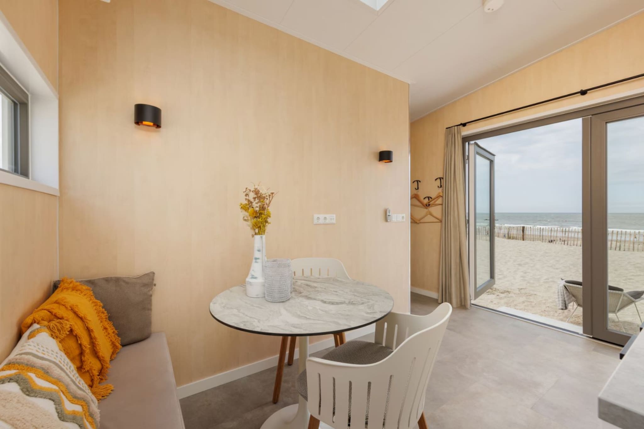 Wake up to the ultimate holiday feeling with the beach literally at your feet in these modern, detached Beach Houses in Zandvoort. Situated on the second row of a charming seaside park, this accommodation offers a partial sea view and the rare opportunity to escape the hustle and bustle of daily life. The bright, air-conditioned living room is designed for comfort, featuring a cozy sitting area and an open-plan kitchen equipped with an induction cooktop, refrigerator-freezer, and coffee pod machine. Through the patio doors, you can step directly onto your private veranda to enjoy the morning sun or relax in the evening to the gentle rhythm of the North Sea.

The clever layout comfortably accommodates up to four guests, offering a primary bedroom with two single beds and a charming, traditional box bed that sleeps an additional two. The interior remains functional and modern, with a bathroom featuring a shower and sink, plus a separate toilet for added privacy. To ensure a comfortable stay in any season, the home is equipped with high-performance air conditioning to keep the space cool in the summer and warm during the spring and autumn months. Guests also enjoy free Wi-Fi and the peace of mind provided by integrated smoke and carbon monoxide detectors.

Zandvoort is a vibrant coastal destination offering everything from adrenaline-filled days at the nearby F1 circuit to peaceful hikes through the Amsterdam Water Supply Dunes. Water sports enthusiasts can indulge in surfing, kitesurfing, or paddleboarding, while culture seekers can reach the historic center of Haarlem in less than 10 kilometers. While the beach houses are located in a tranquil, car-free zone, affordable multi-day parking can be arranged via the local municipality.