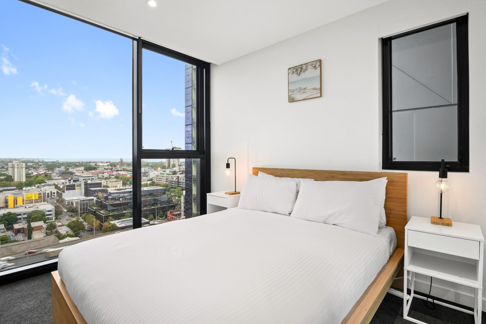 Property description
Located high above Southbank, this modern apartment offers sweeping city and bay views with a private balcony to enjoy Melbourne’s skyline. The open-plan living space creates a relaxed city retreat, while the building provides access to a pool and premium facilities. With easy access to Melbourne’s dining, arts, and entertainment precincts, it’s a convenient base for both business and leisure stays.
The space
Perched high on the nineteenth floor, this modern apartment offers expansive views across Melbourne’s city skyline and towards the bay. The open-plan living and dining area is filled with natural light, creating a welcoming space to relax after a day exploring the city. A comfortable two-seat sofa, coffee table, and dining table for four provide a functional yet inviting setting for meals, work, or quiet evenings indoors.
 
Sliding doors lead out to a private balcony with outdoor seating, where guests can take in the elevated city views and fresh air. The kitchen features a streamlined layout with modern appliances and ample bench space, making it easy to prepare simple meals during your stay.
 
Both bedrooms are designed for comfort, each featuring a queen bed, bedside tables, lamps, and blackout blinds for restful nights. The apartment includes a well-appointed bathroom with contemporary fittings and storage space.
 
Additional conveniences include a private laundry with washer and dryer, along with secure building access and lift access to the apartment. Guests can also enjoy the building’s pool located on Level 41, providing a relaxing escape with impressive views above the city.