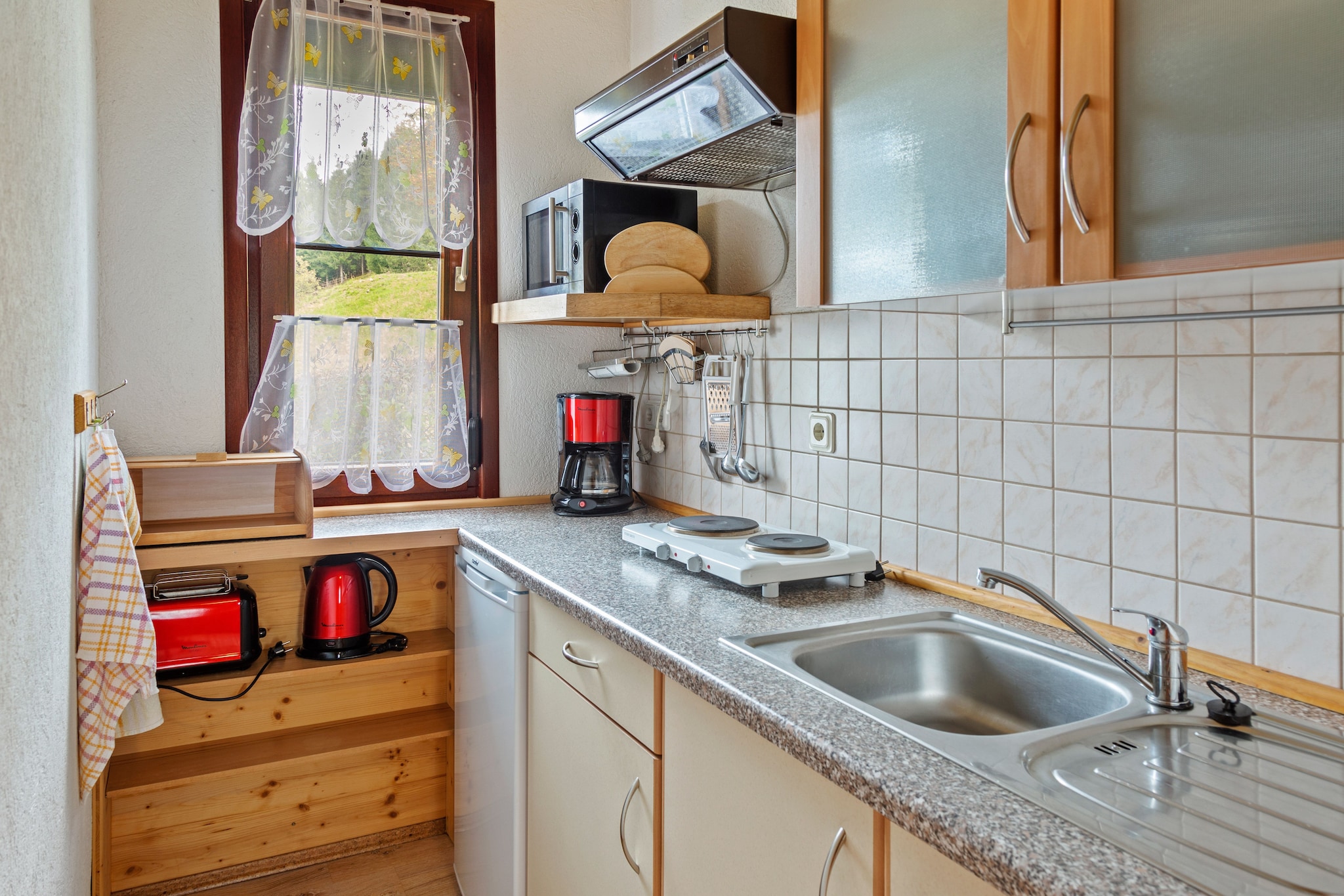 Ground floor: (Entrance, hall, Kitchen(coffee machine, microwave, fridge-freezer), Living/diningroom(TV(satellite), stove(wood, tiled), radio), bedroom(double bed), bathroom(shower, washbasin, toilet))\n\nterrace(private), garden(private), garden furniture, BBQ, parking