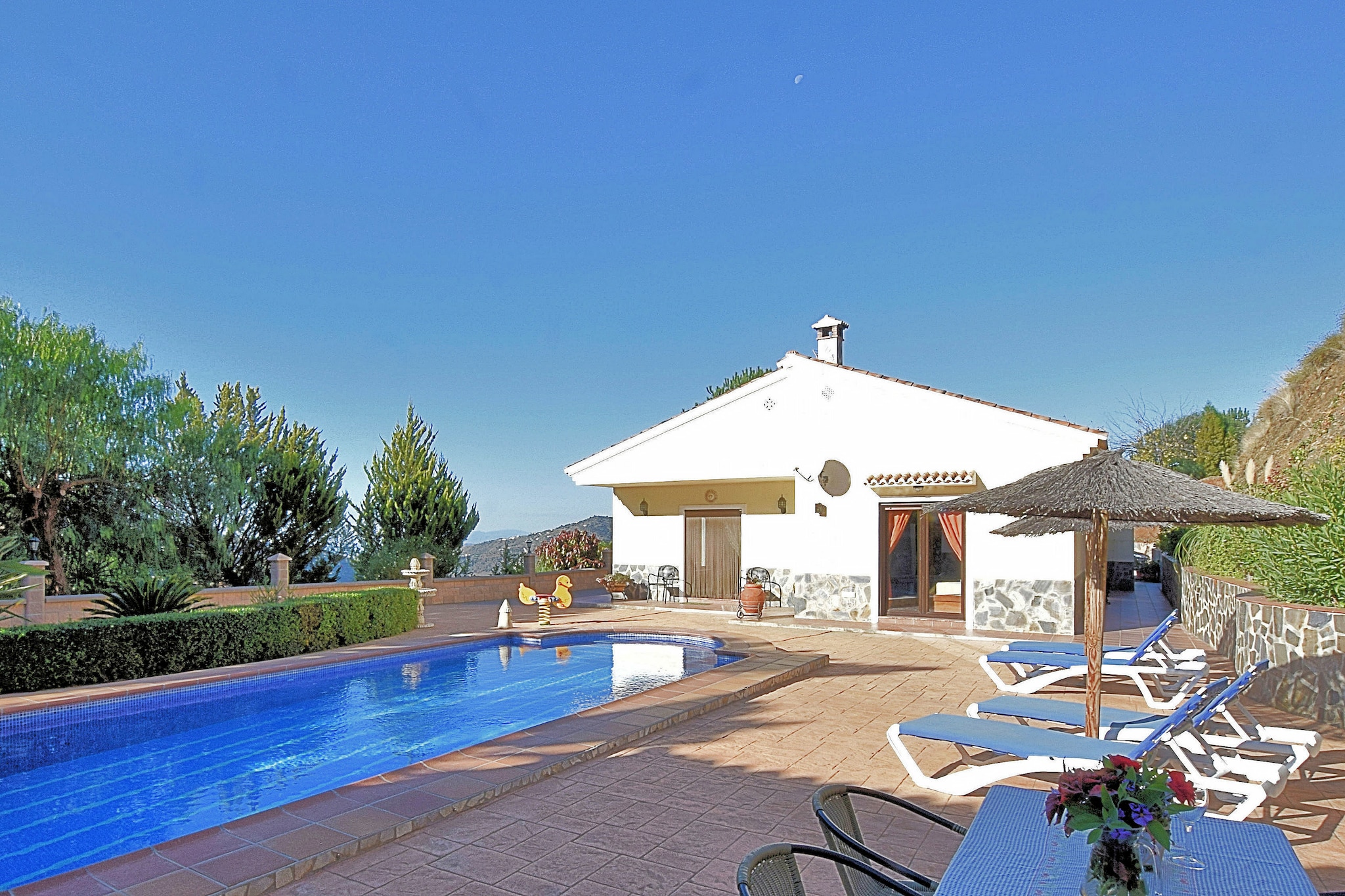This is a gorgeous 3-bedroom villa in Sayalonga,Andalusia that houses 6 people. Located on the scenic Costa del Sol, it offers a magnificent view of the Mediterranean Sea. There's also an outdoor shower and large private swimming pool for a refreshing dip.
The beach of Algarrobo is only 11 km away. Only 8 km away is the beautiful village of Cómpeta where you'll find a variety of restaurants and the wonderful regional Moscatel wine. Málaga, with its beautiful promenade by the harbour, the Alcazaba, lovely museums, and tapas bars is 47 km away. You can get groceries and dine out in Sayalonga just 1 km away.
The home has a garden with furniture and a terrace with a barbecue and bar. It is child-friendly, and a children’s bed and high chair is available on request.
The Malaga airport is 61 km away.